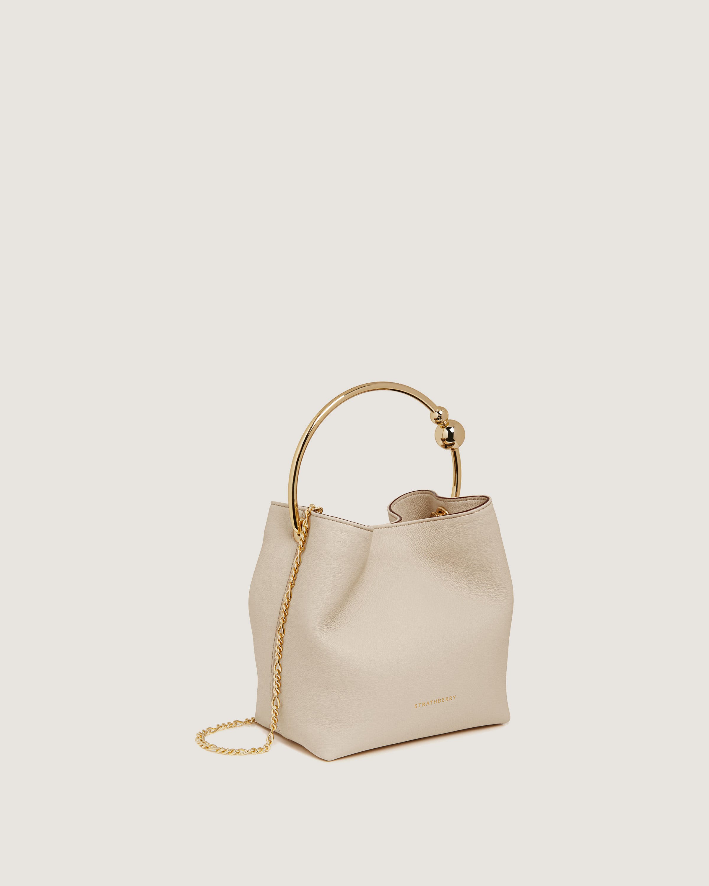 A white handbag with a gold handle