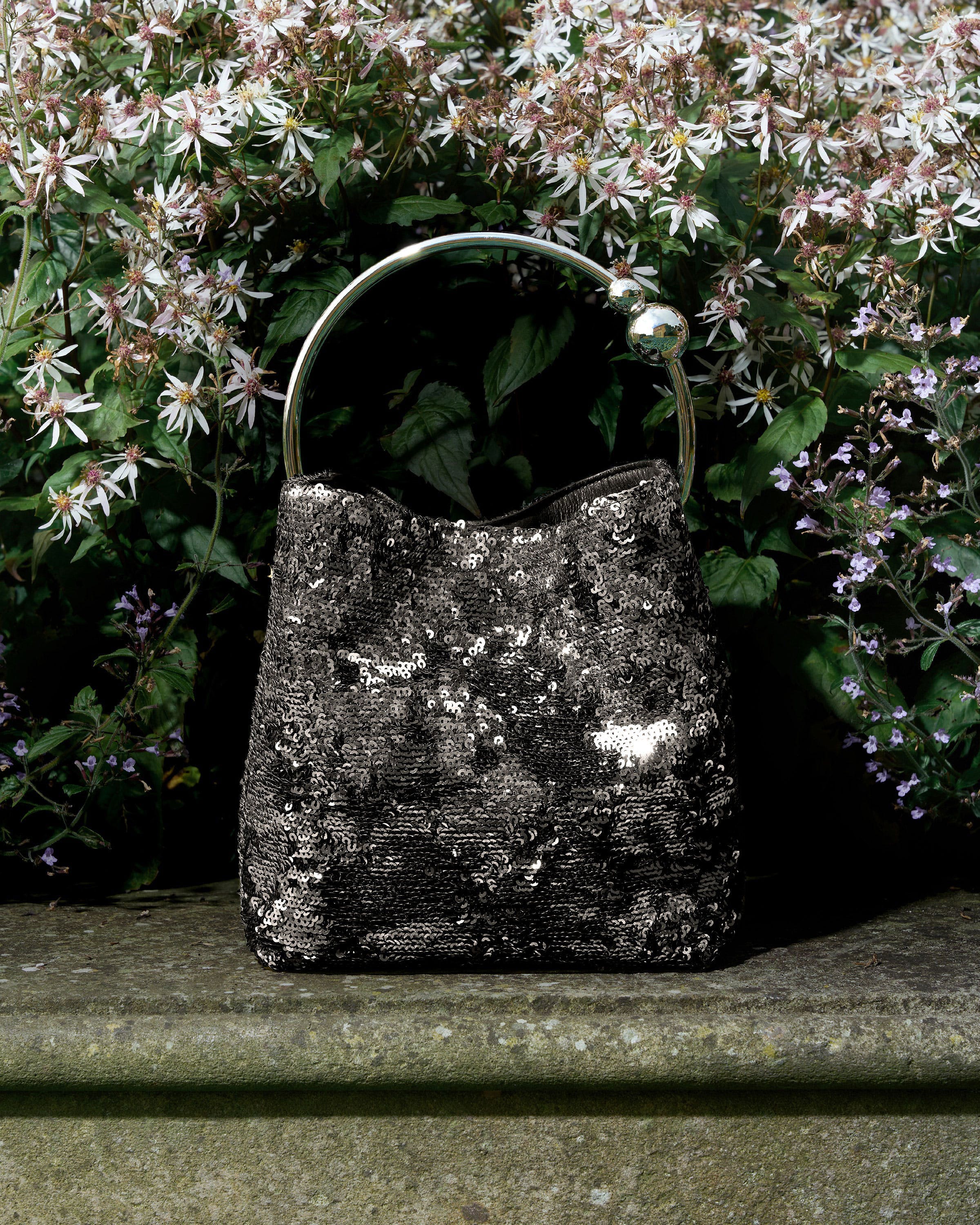 A black and white purse sitting on top of a stone bench