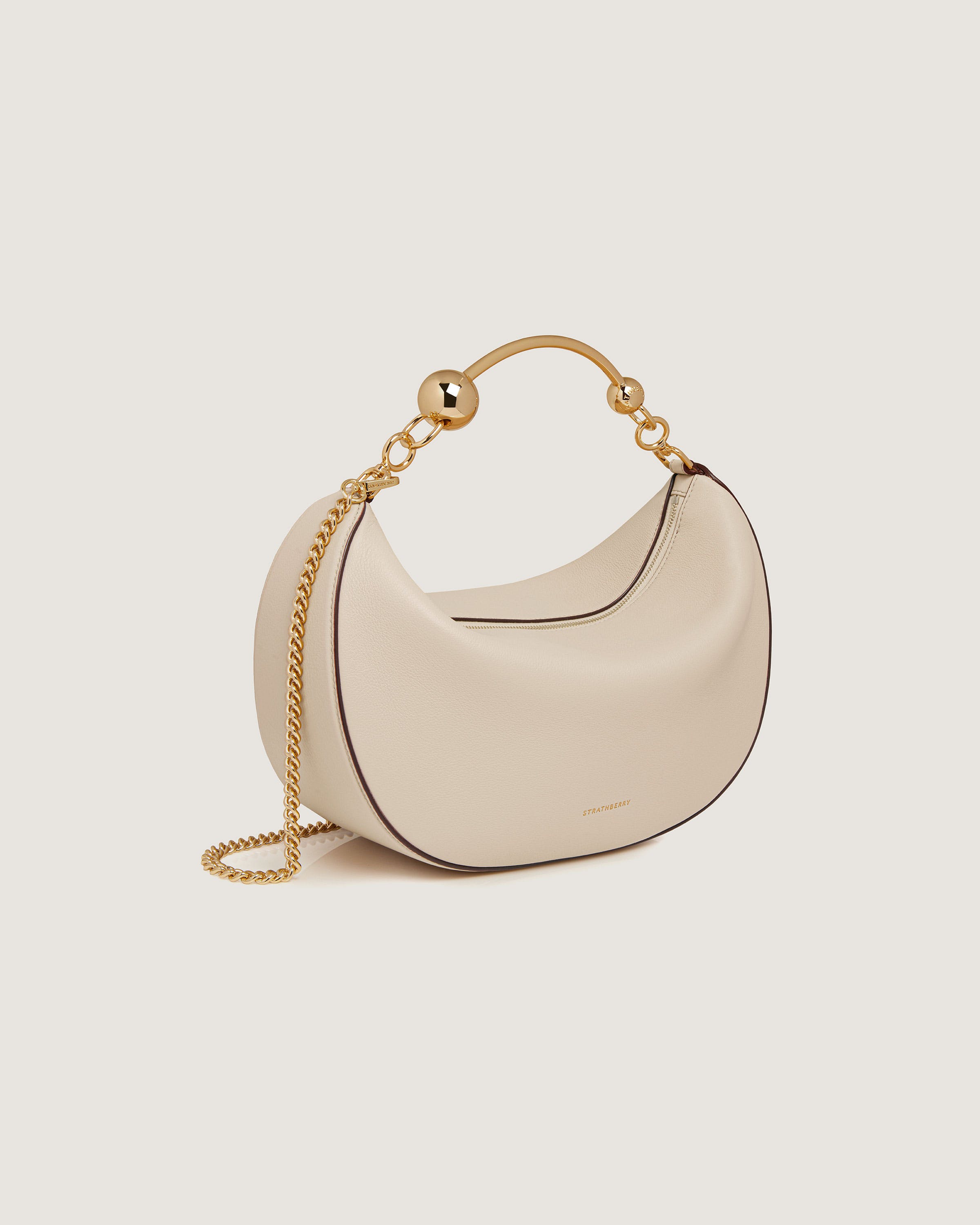 A white purse with a gold chain around it