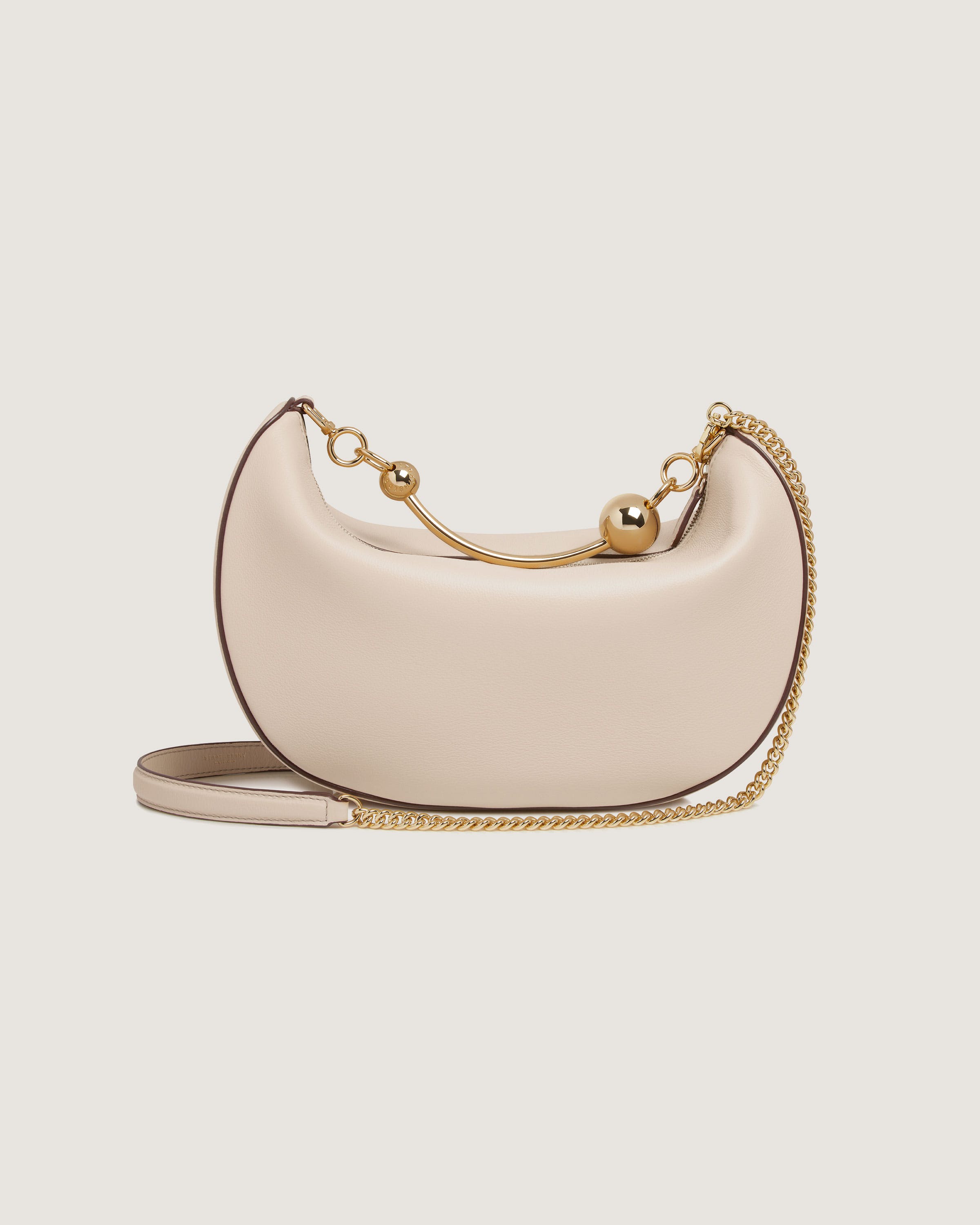 A white purse with a gold chain strap