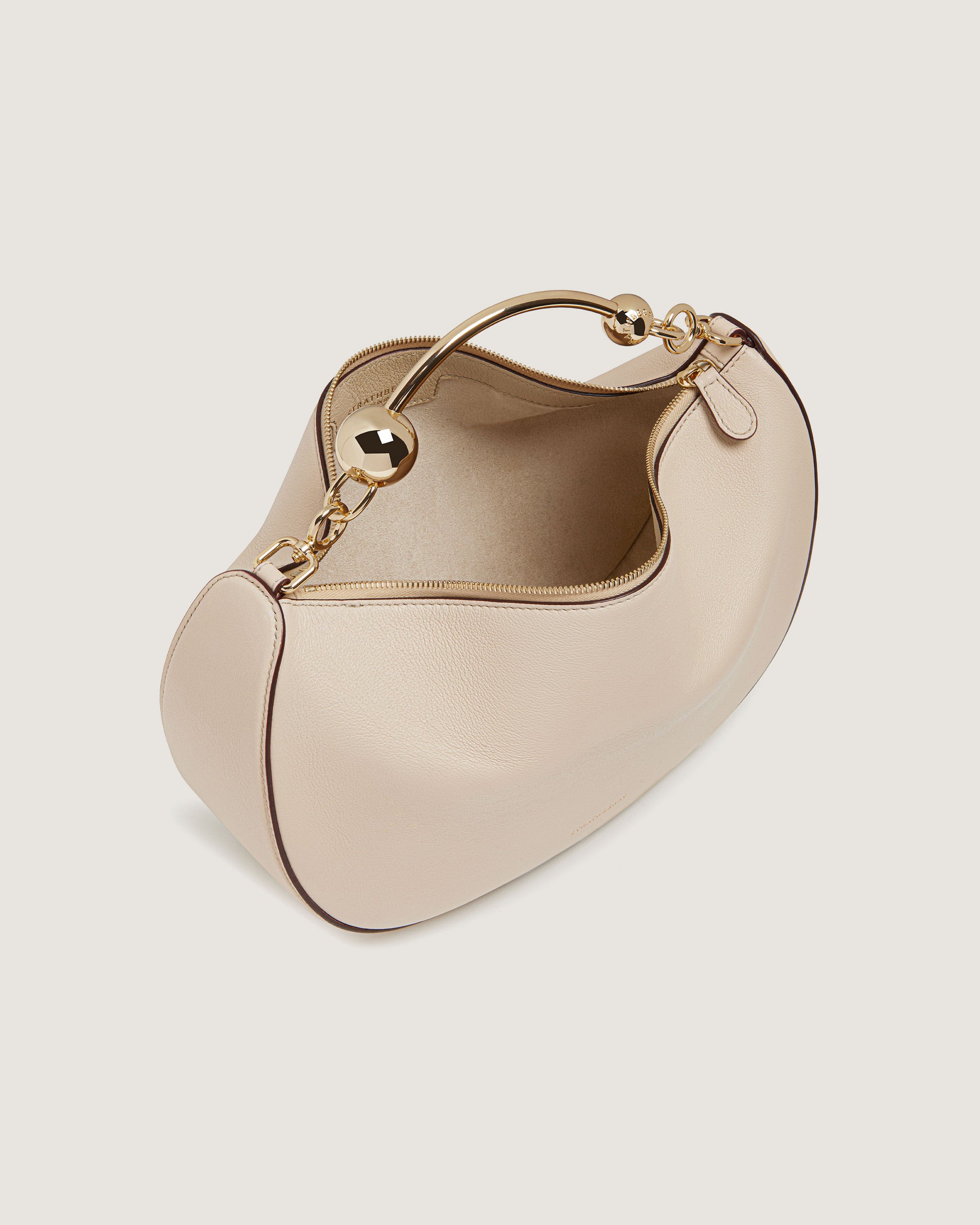 A white handbag with a gold handle