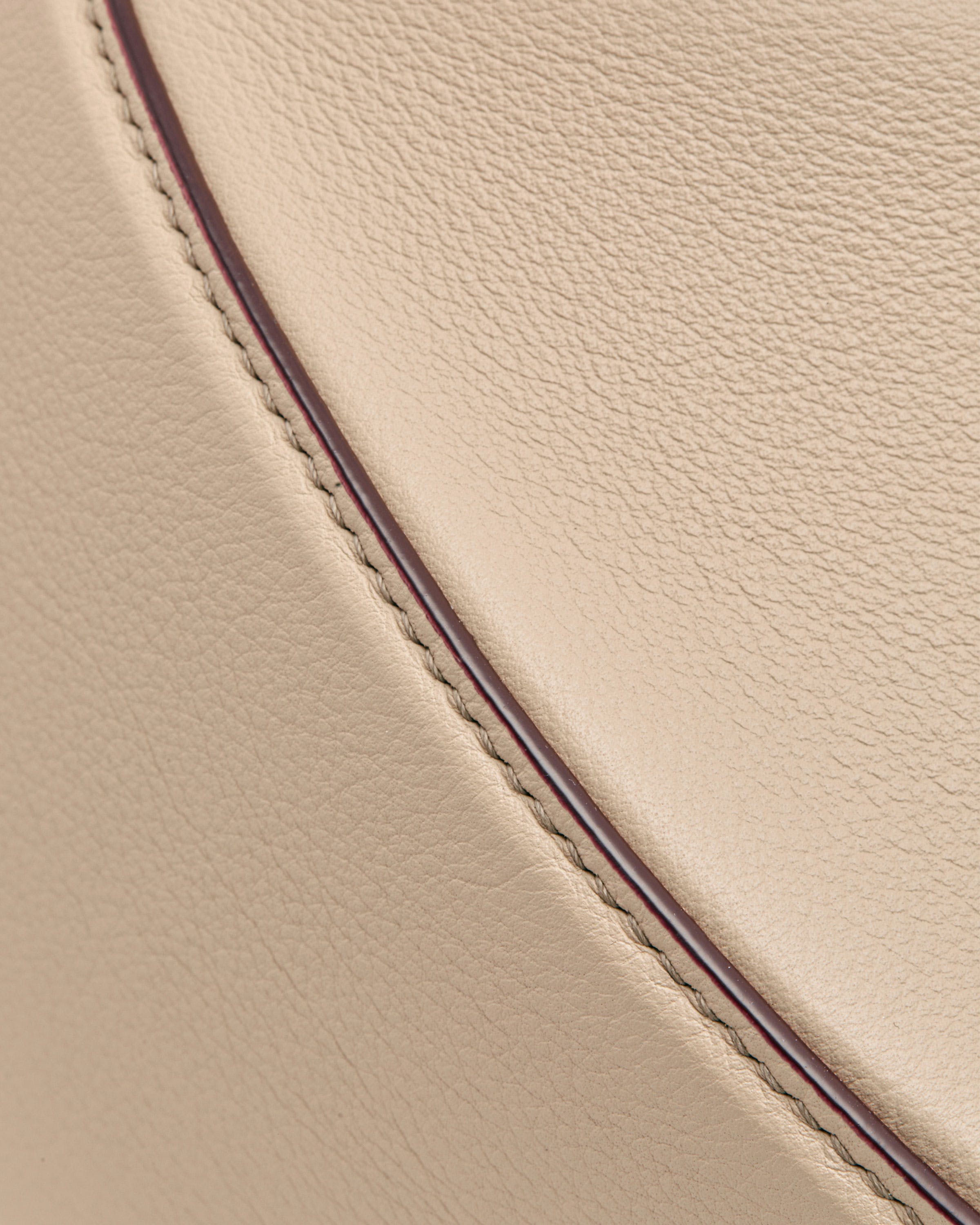 A close up of a beige leather seat