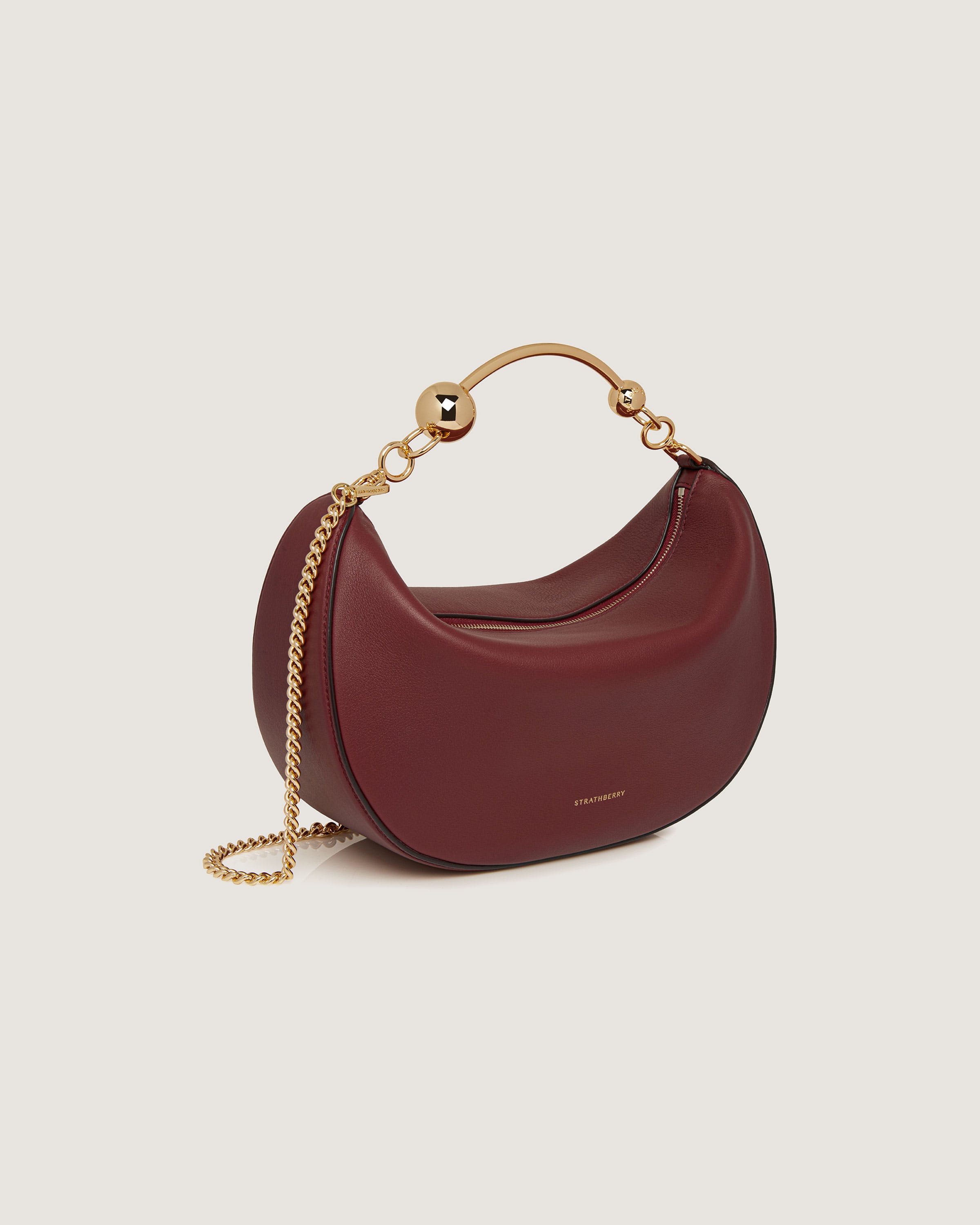 A small red purse with a gold chain