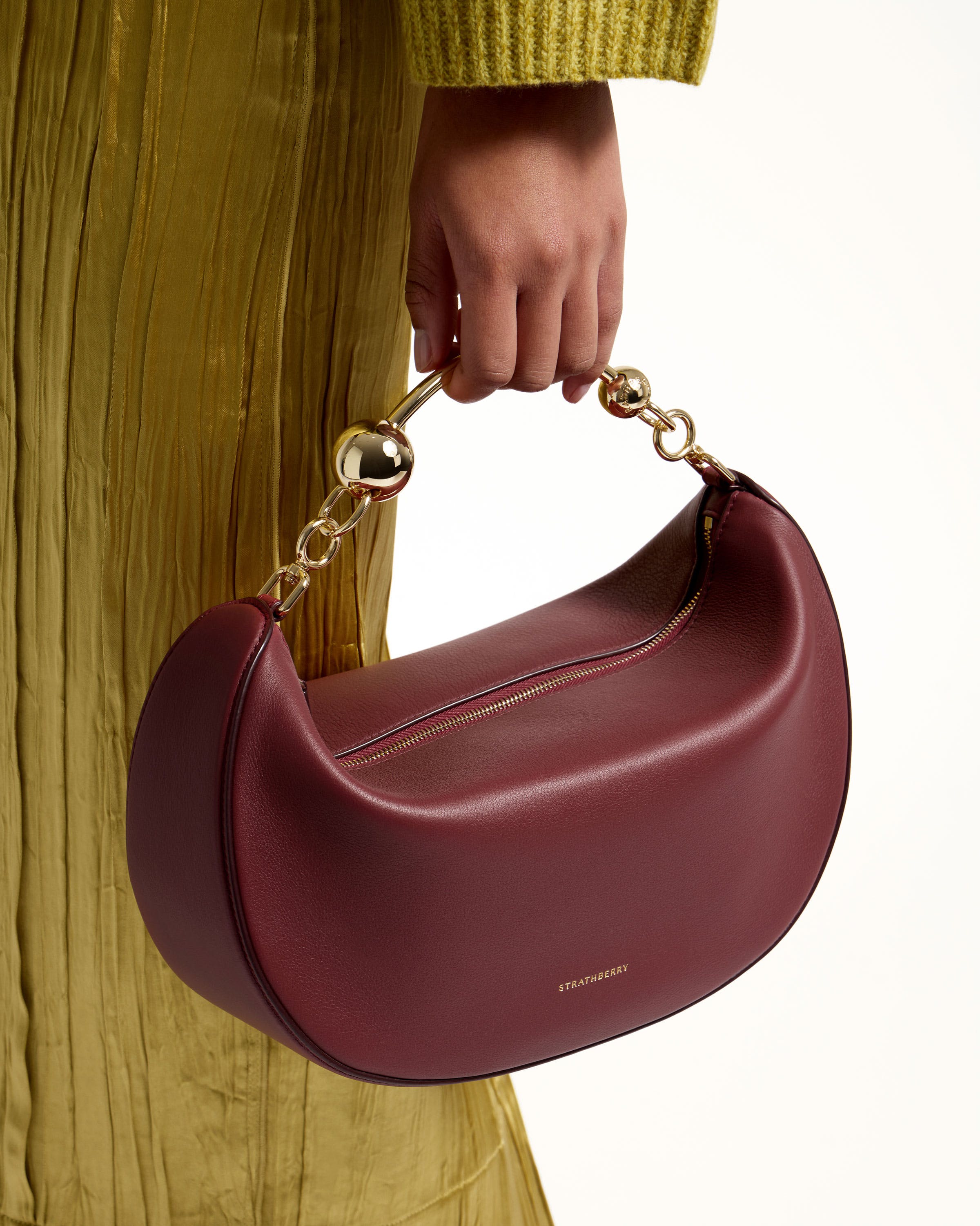 A woman's hand holding a red purse