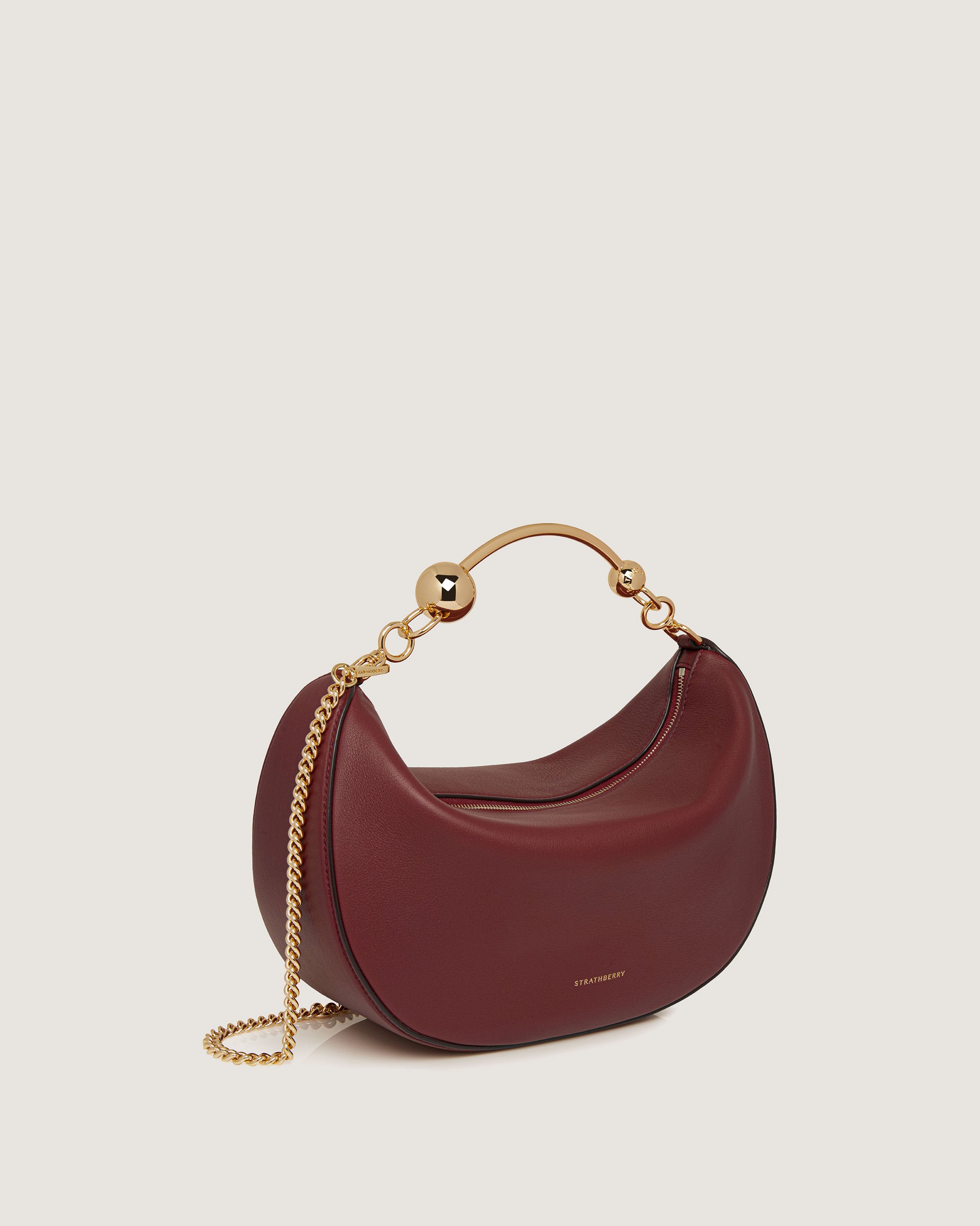 A small red purse with a gold chain