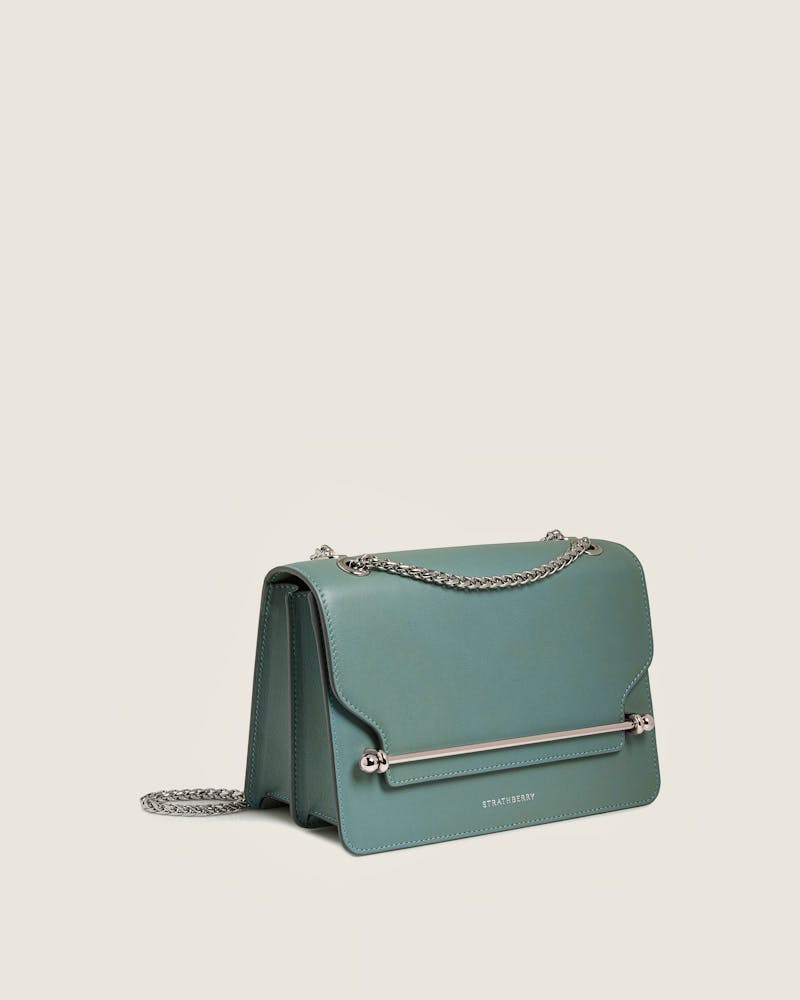 Una piccola borsa verde con tracolla a catena