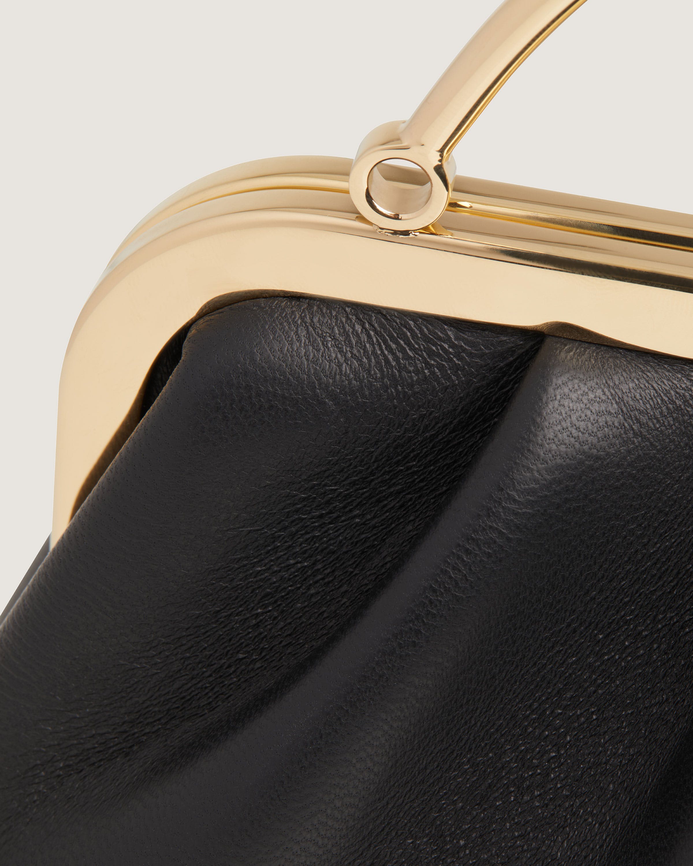 A close up of a black and gold purse