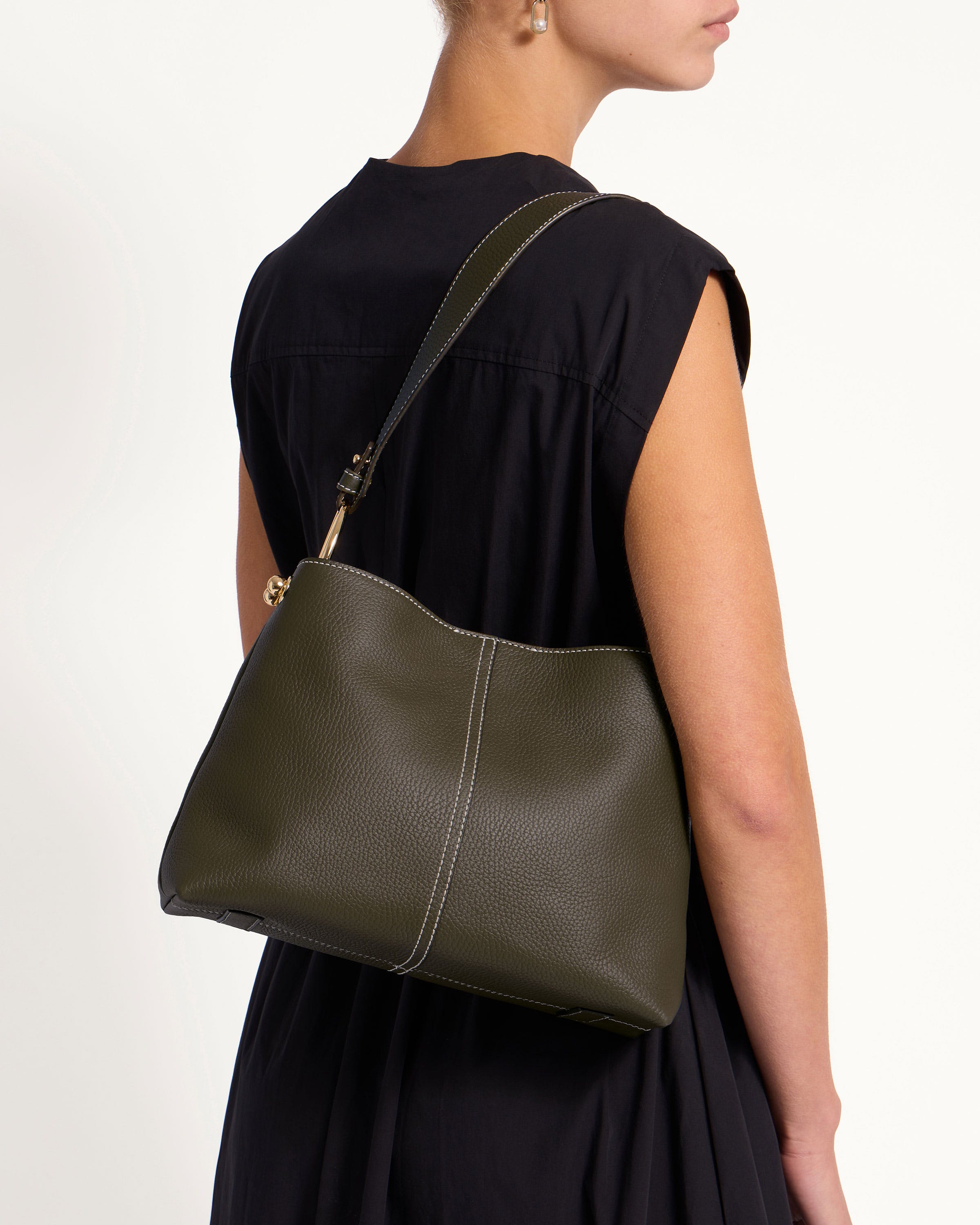 A woman in a black dress carrying a green purse