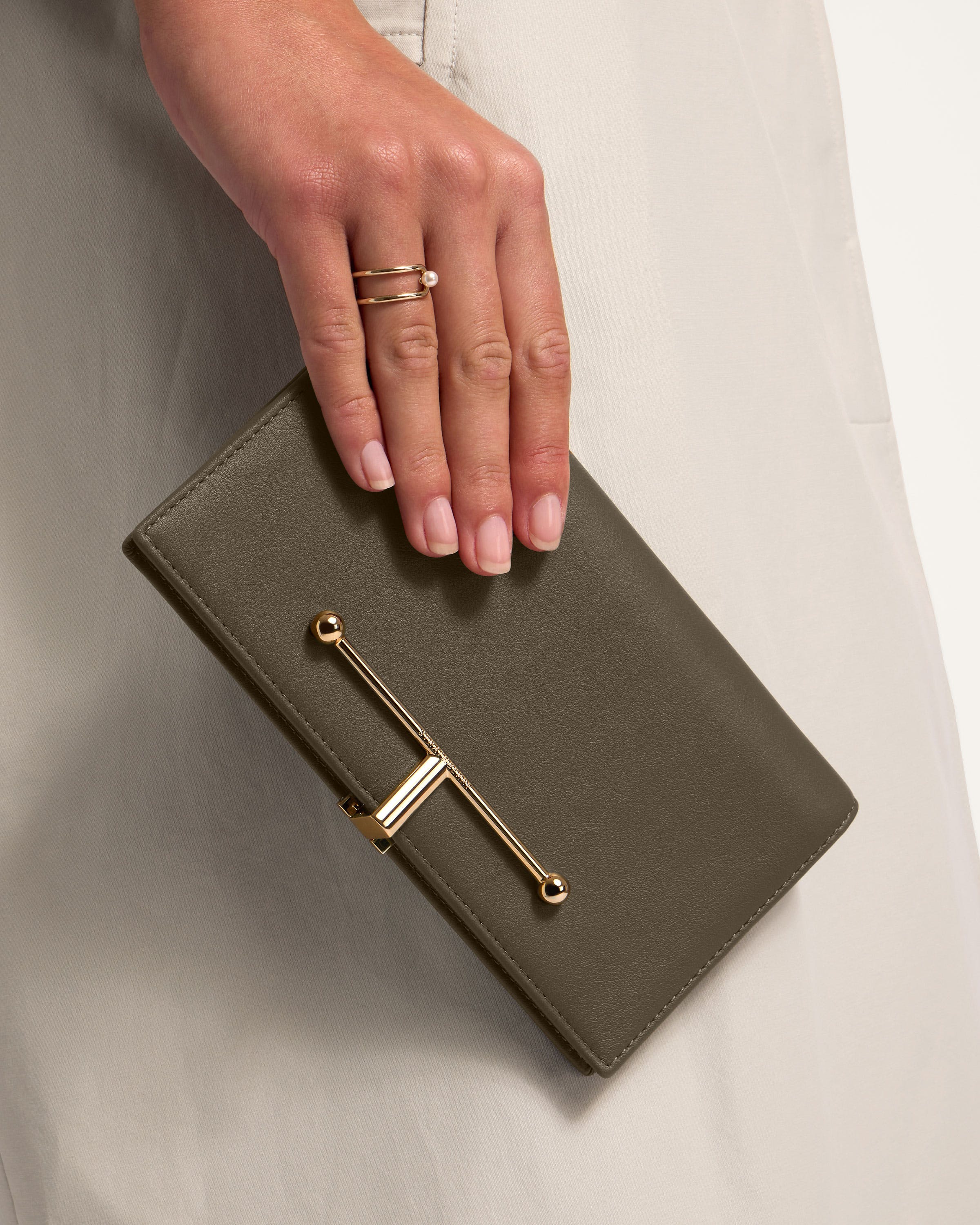 A woman's hand holding a gray purse