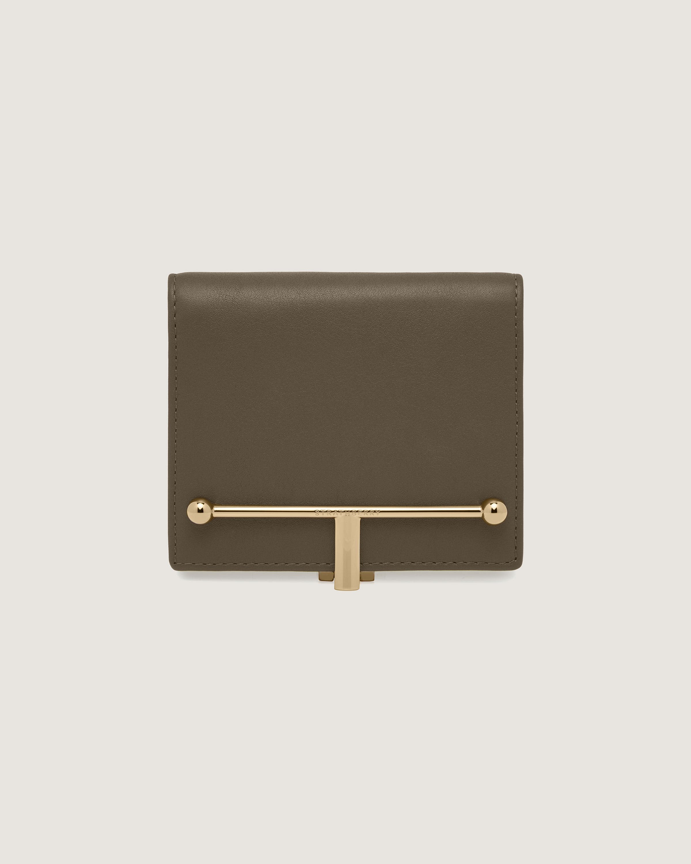 A brown wallet with a gold bar on the front