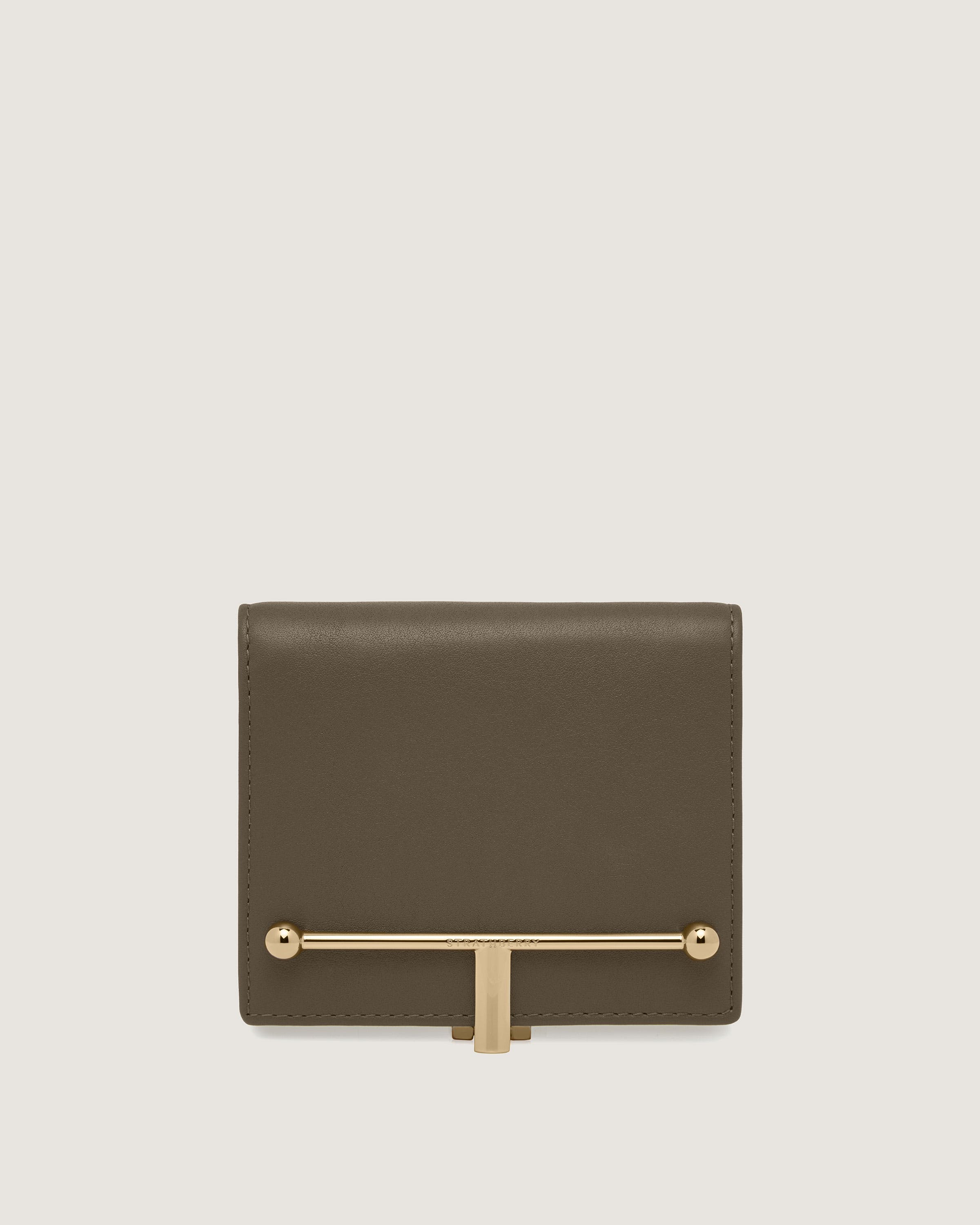 A brown wallet with a gold bar on the front