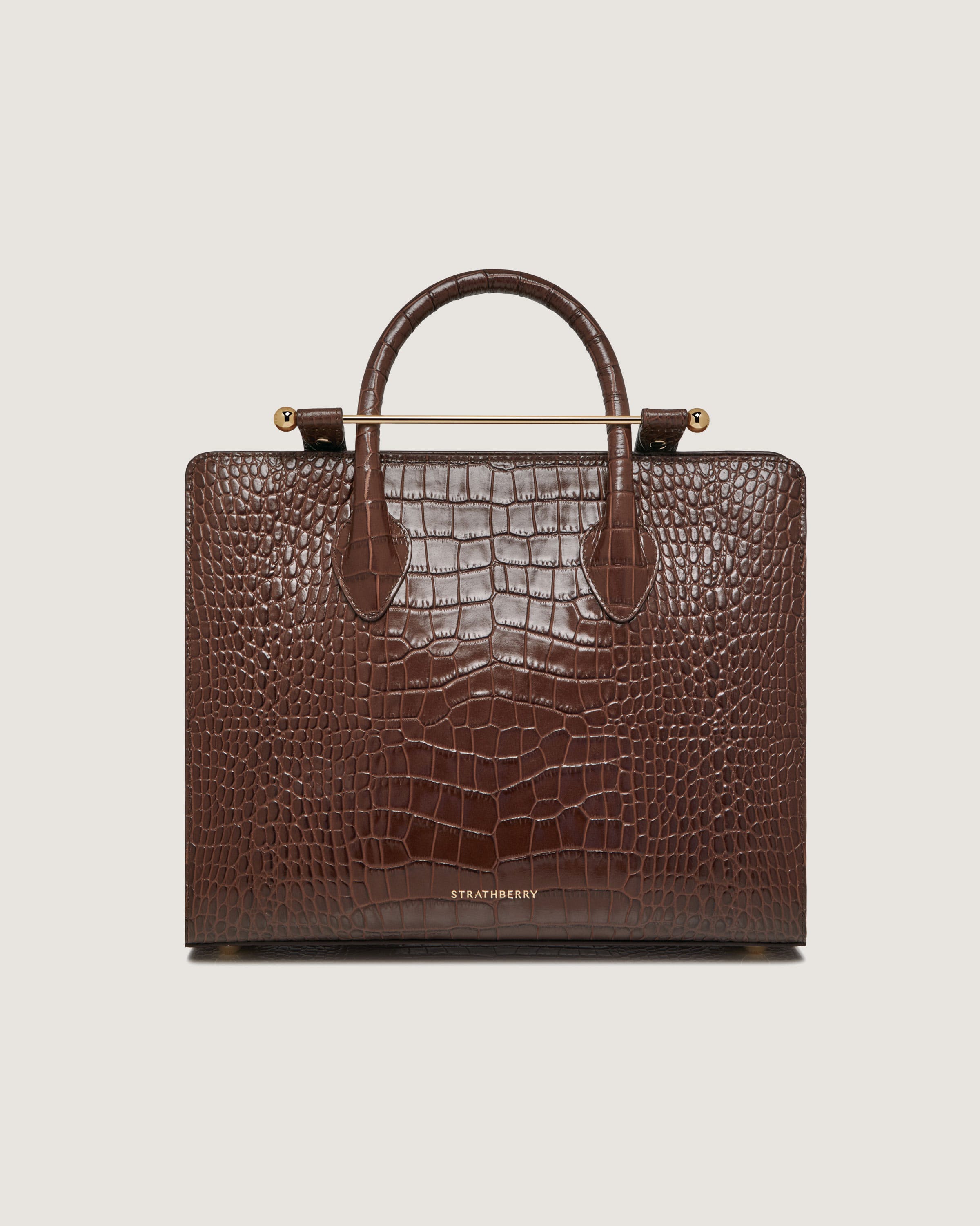 A brown alligator skin briefcase with a handle