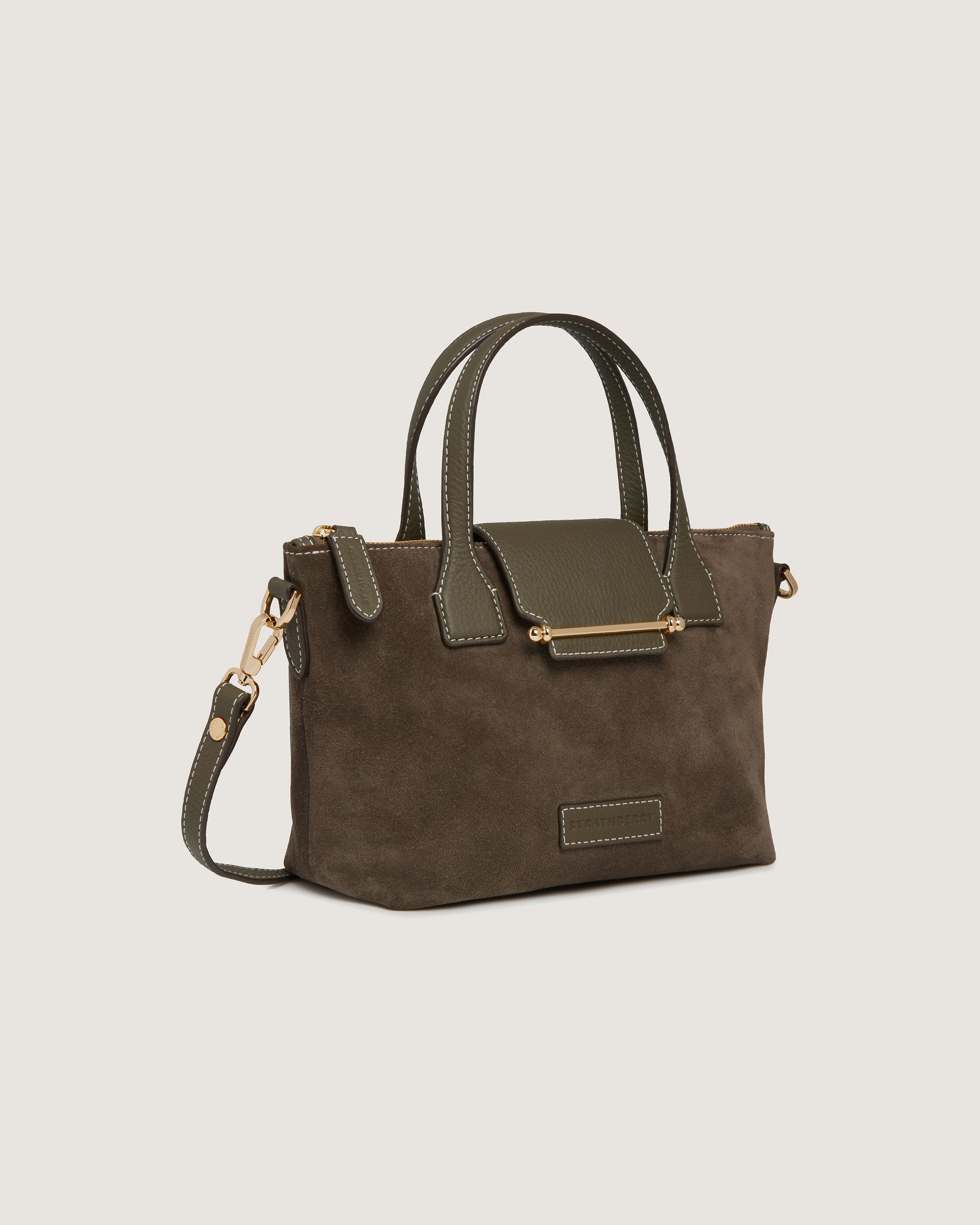 A brown handbag with a green strap