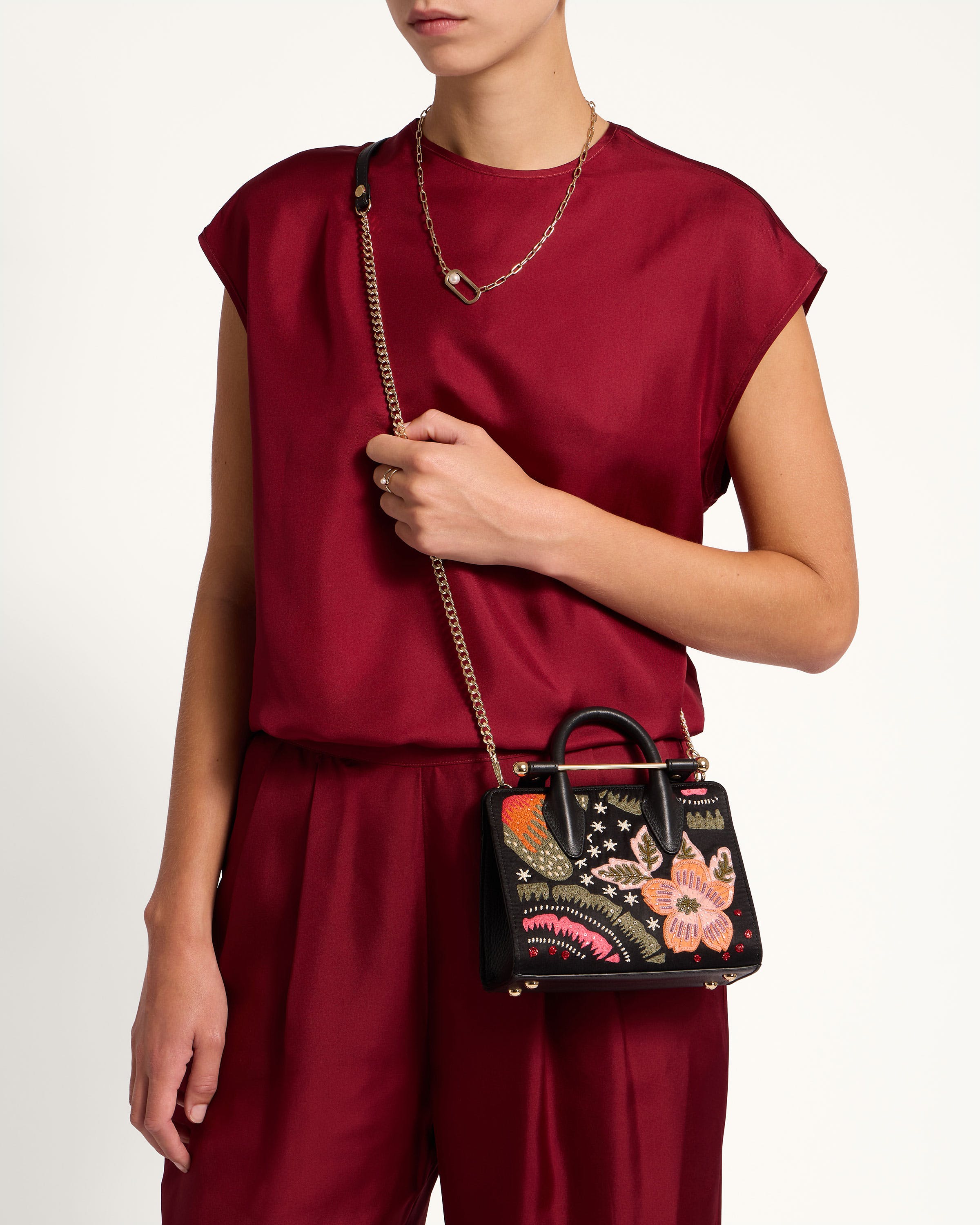 A woman in a red top holding a black purse