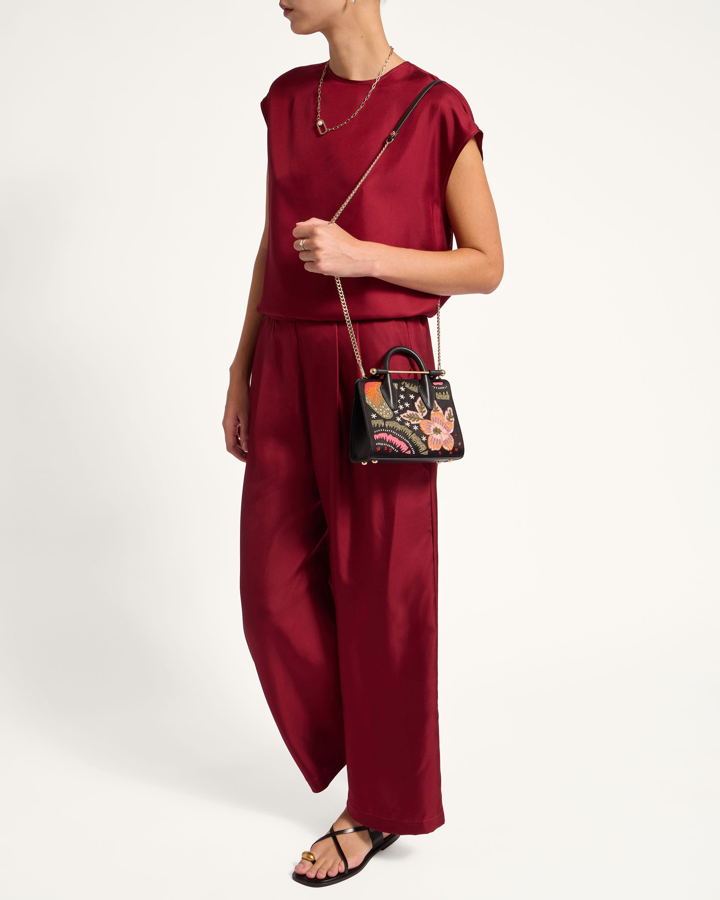 A woman in a red jumpsuit holding a handbag