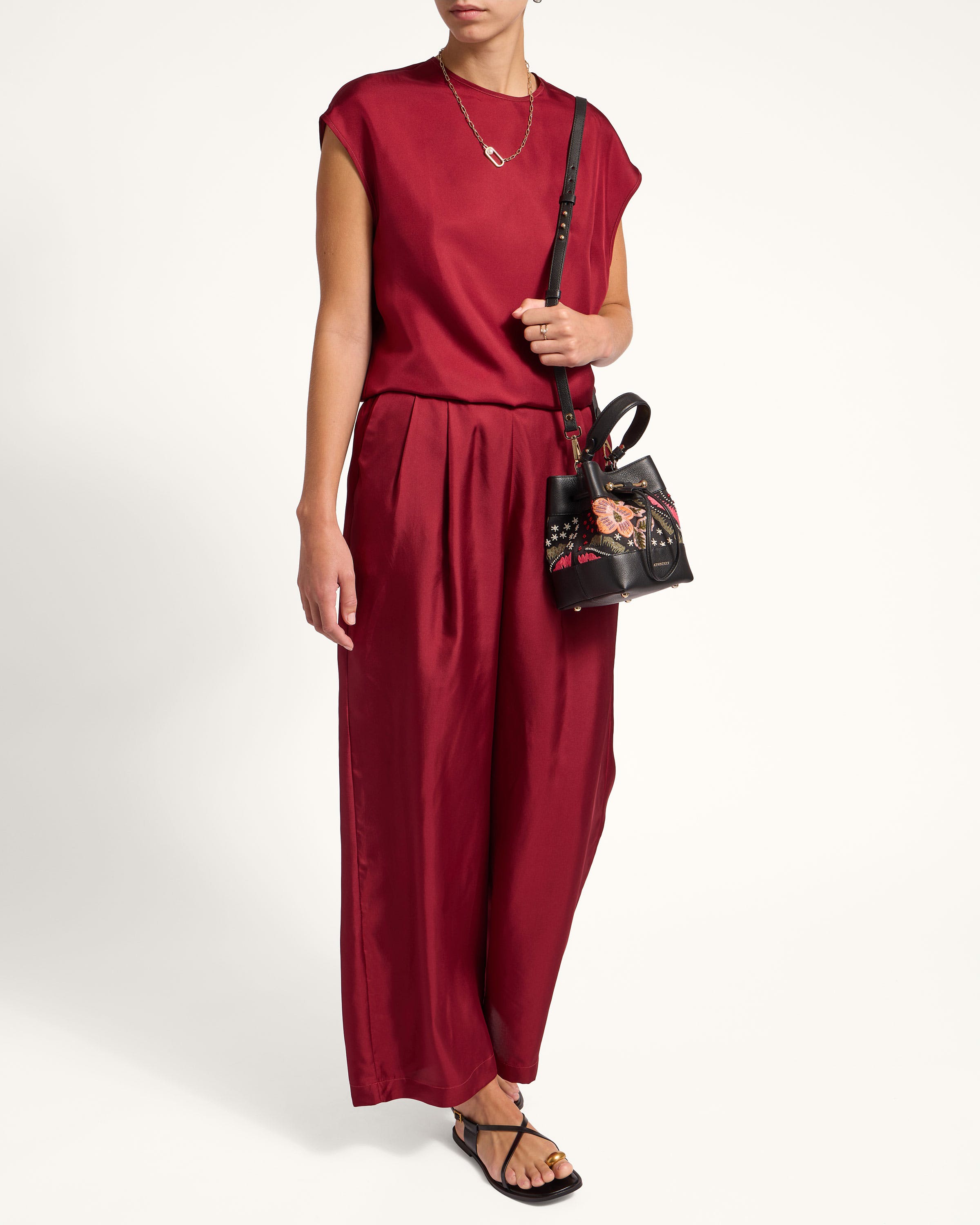 A woman in a red jumpsuit holding a handbag