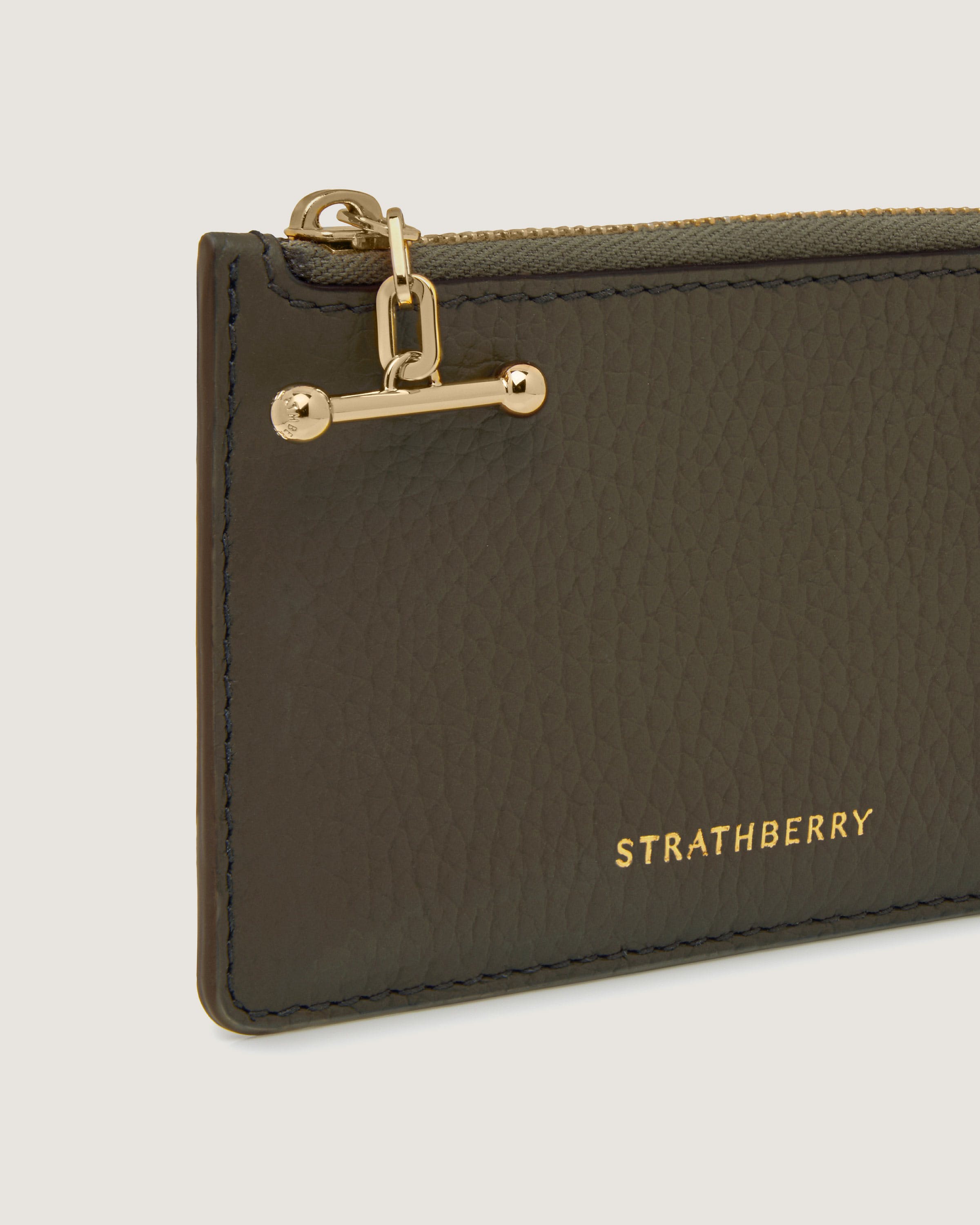 A brown leather card case with a gold chain