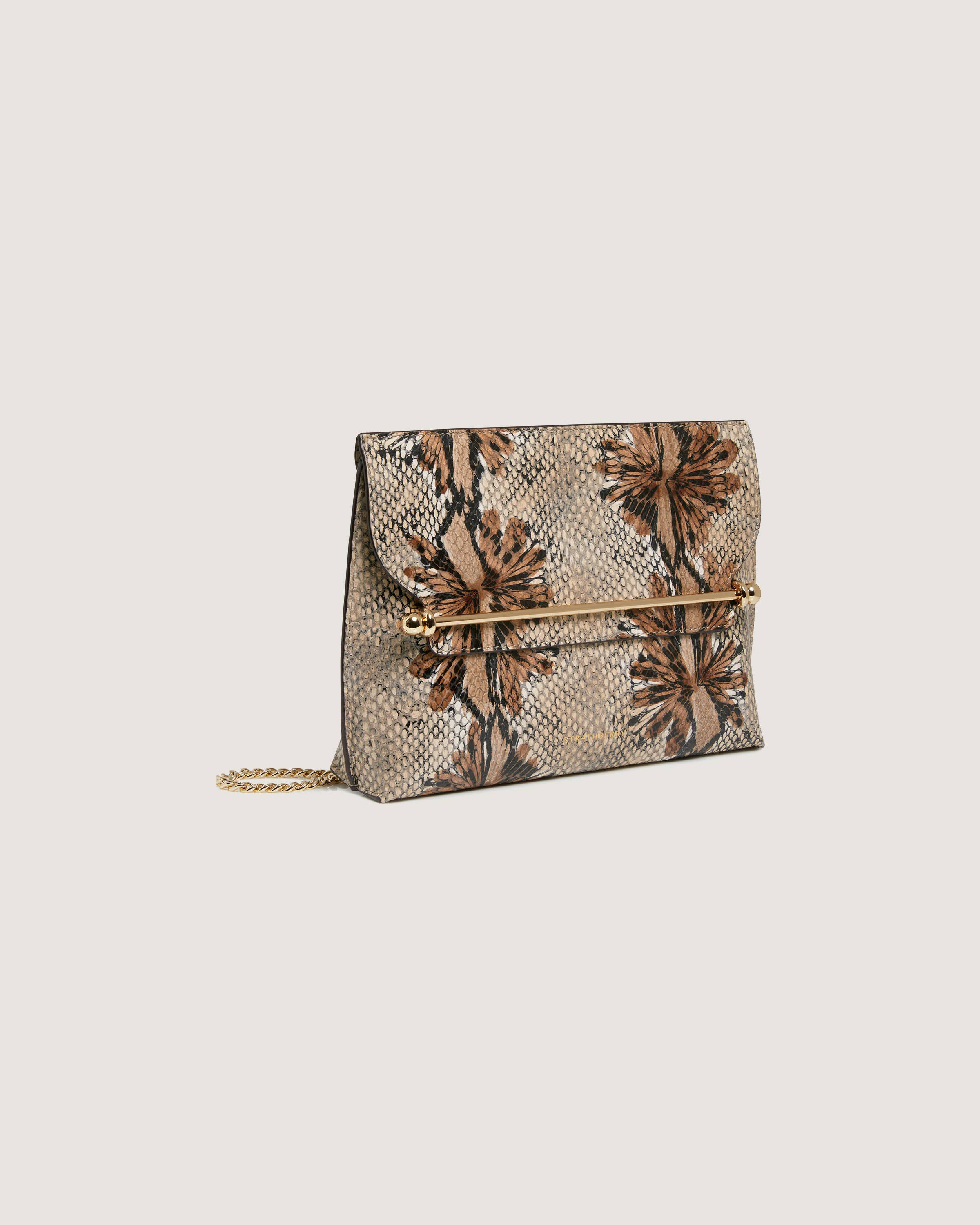 A snake skin clutch bag with a flower design