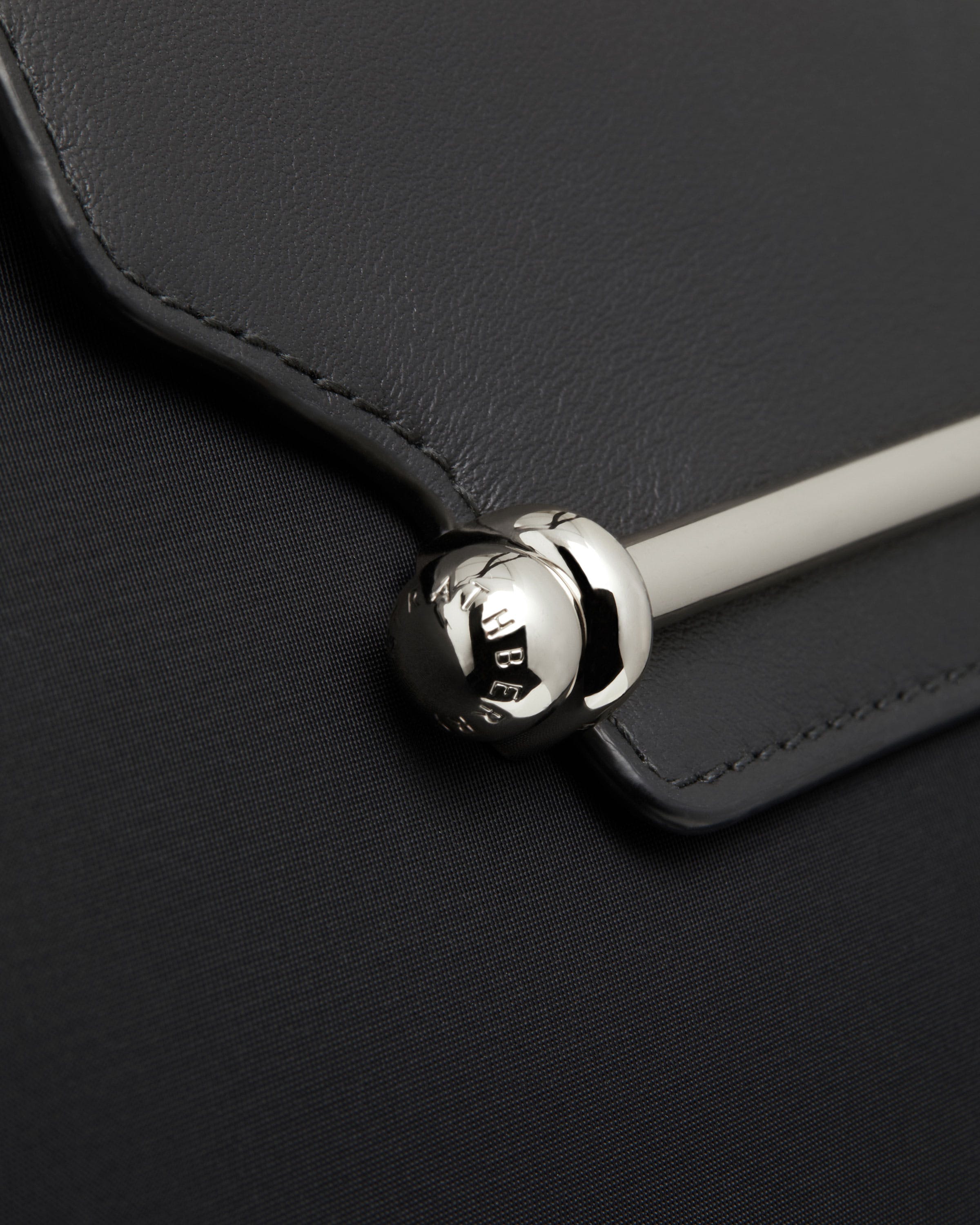 A close up of the handle of a black purse