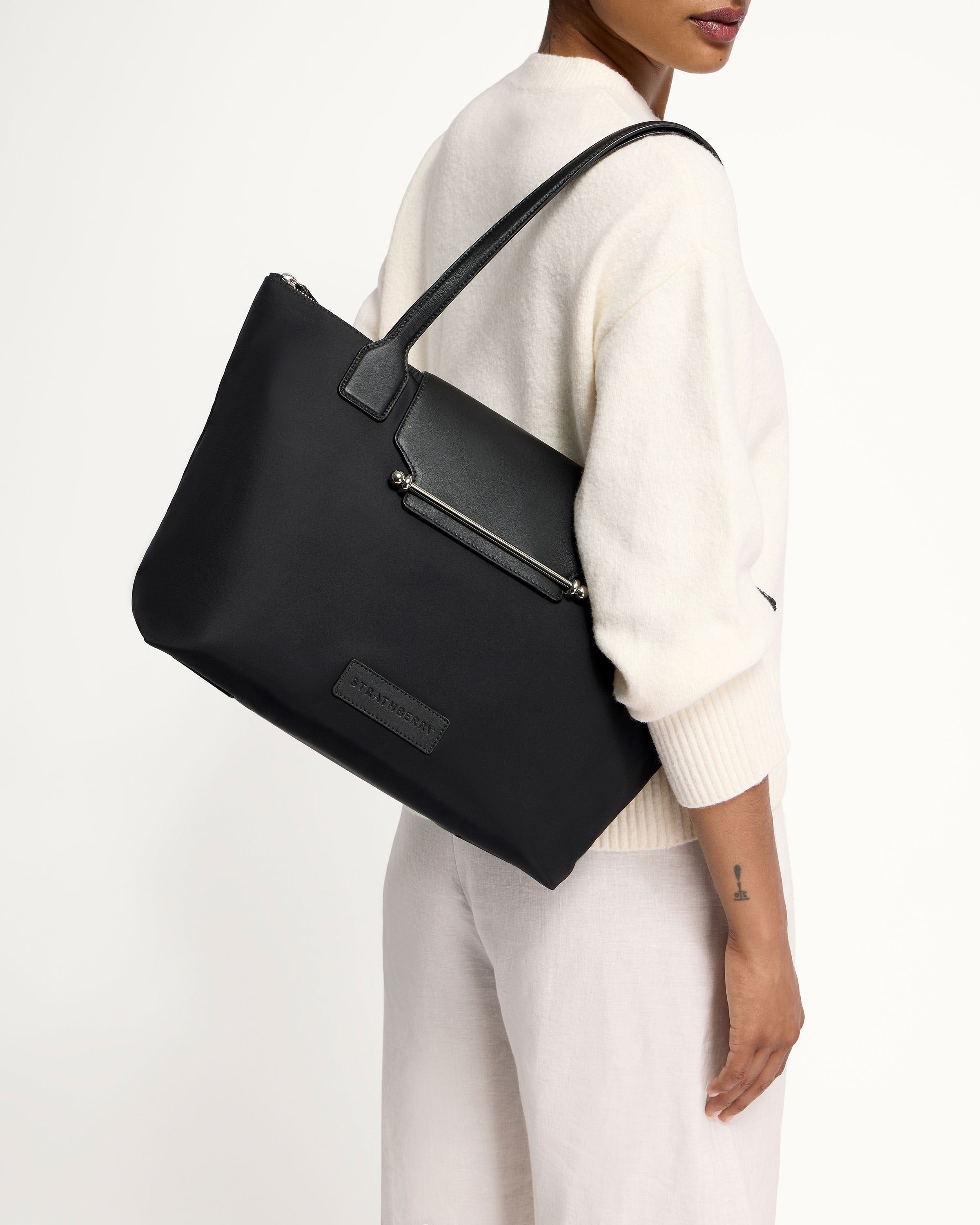 A woman carrying a black leather tote bag