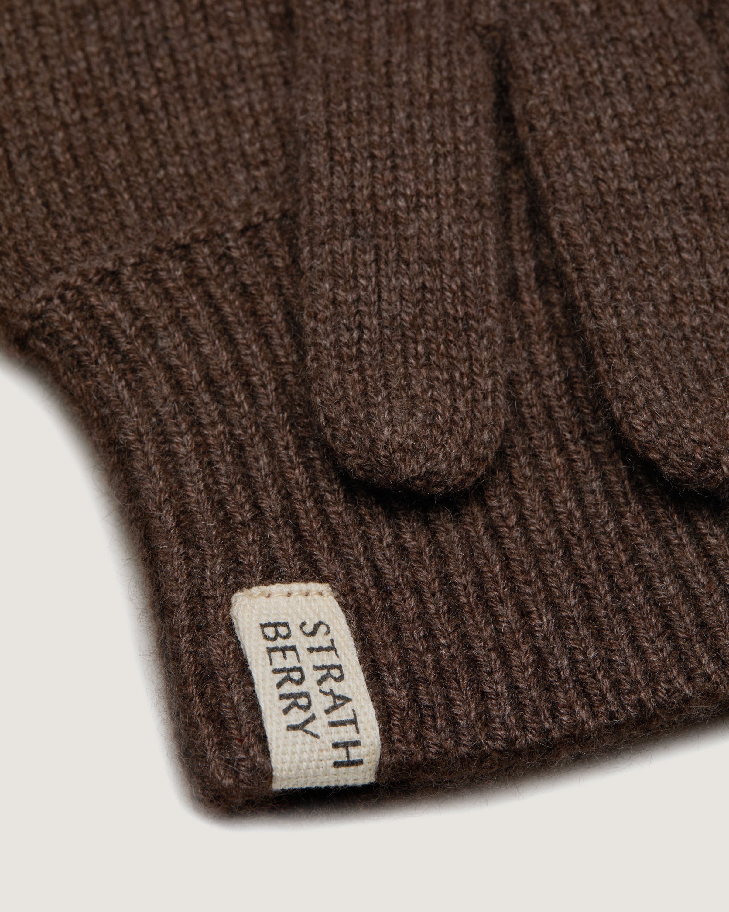 A close up of a brown sweater with a tag on it