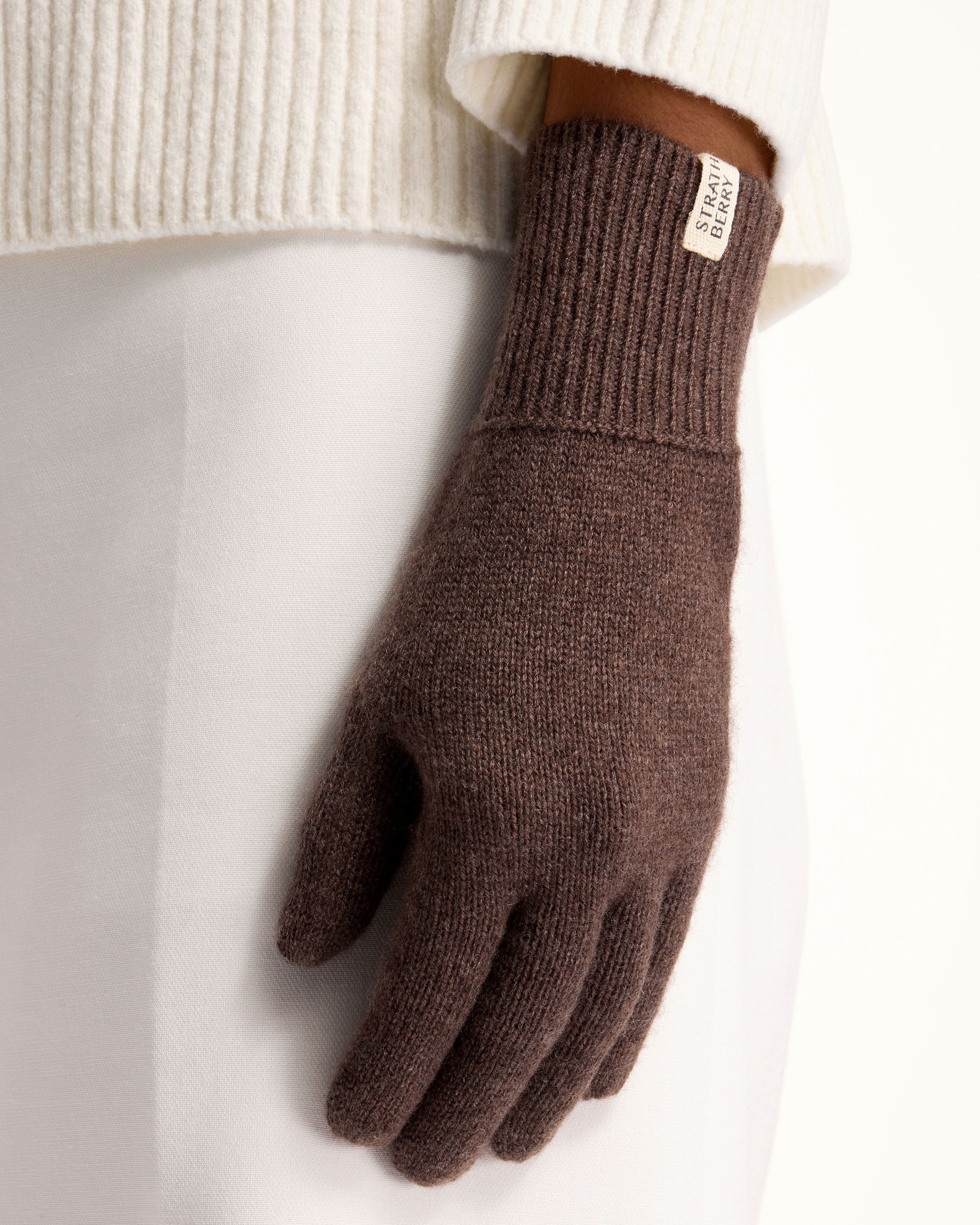 A person wearing a pair of brown gloves