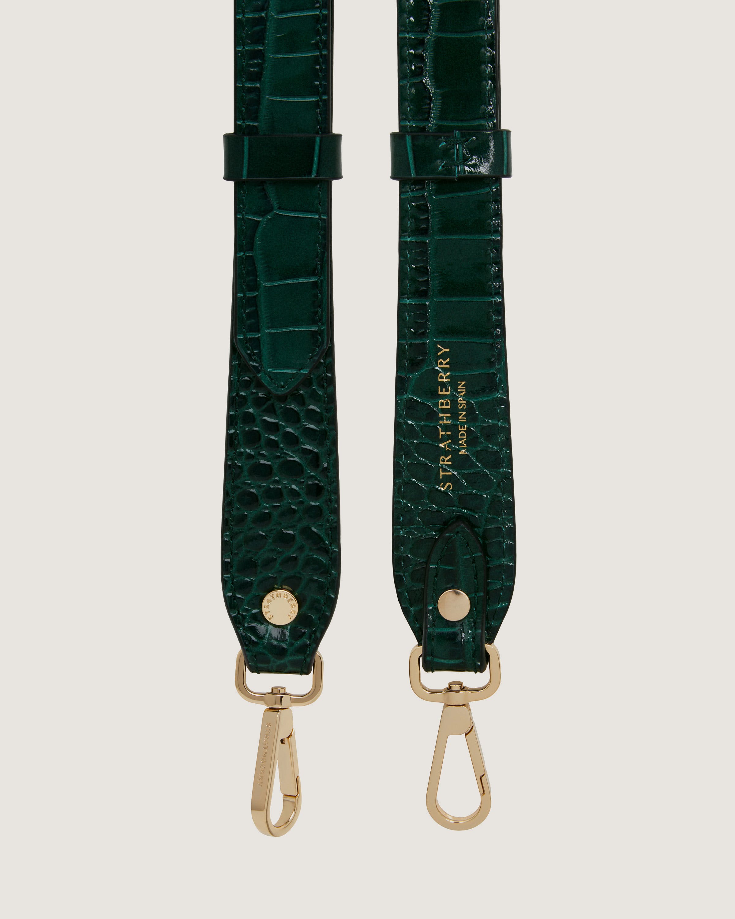 A pair of green alligator - embossed leather straps