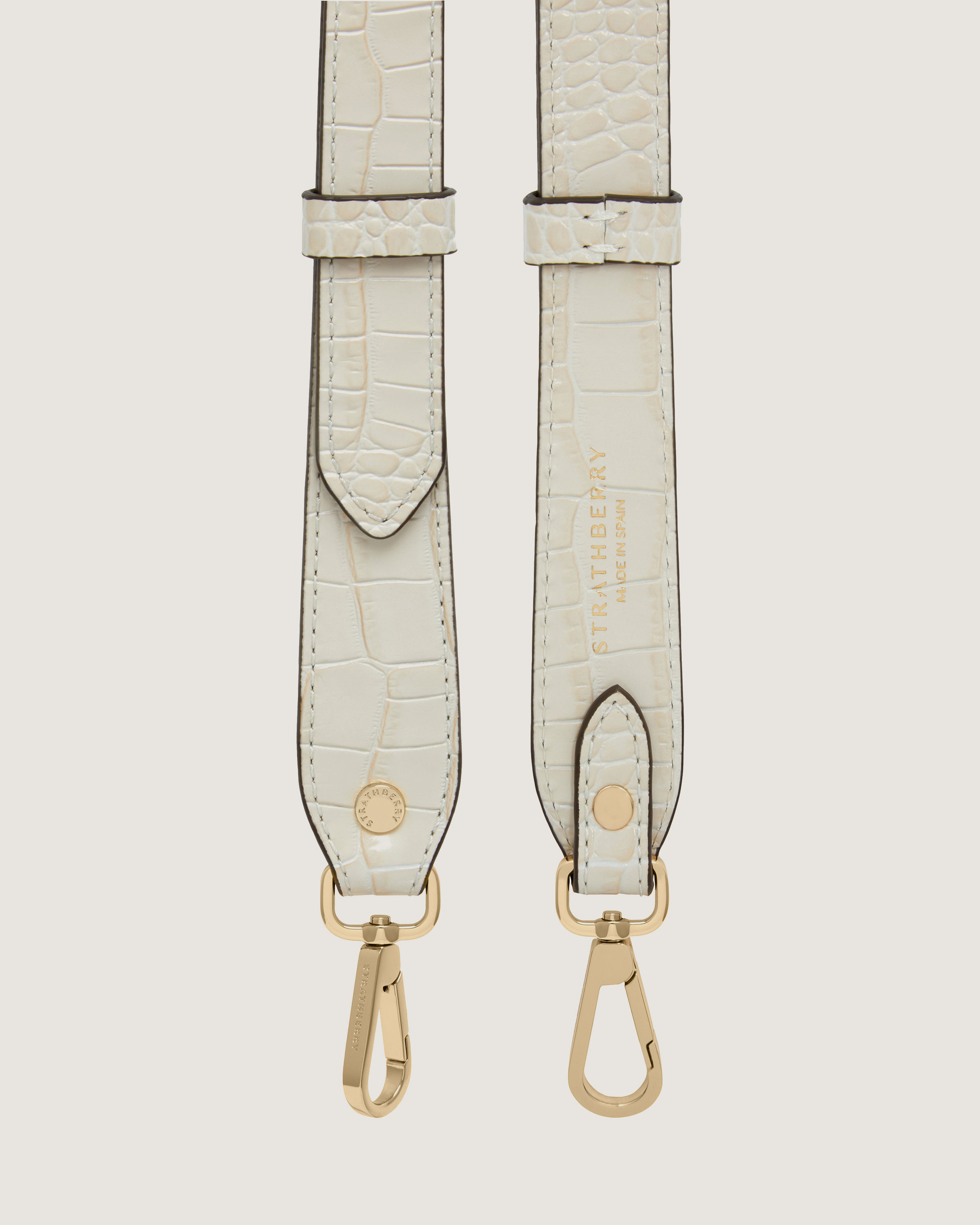 A pair of white alligator - embossed leather suspenders