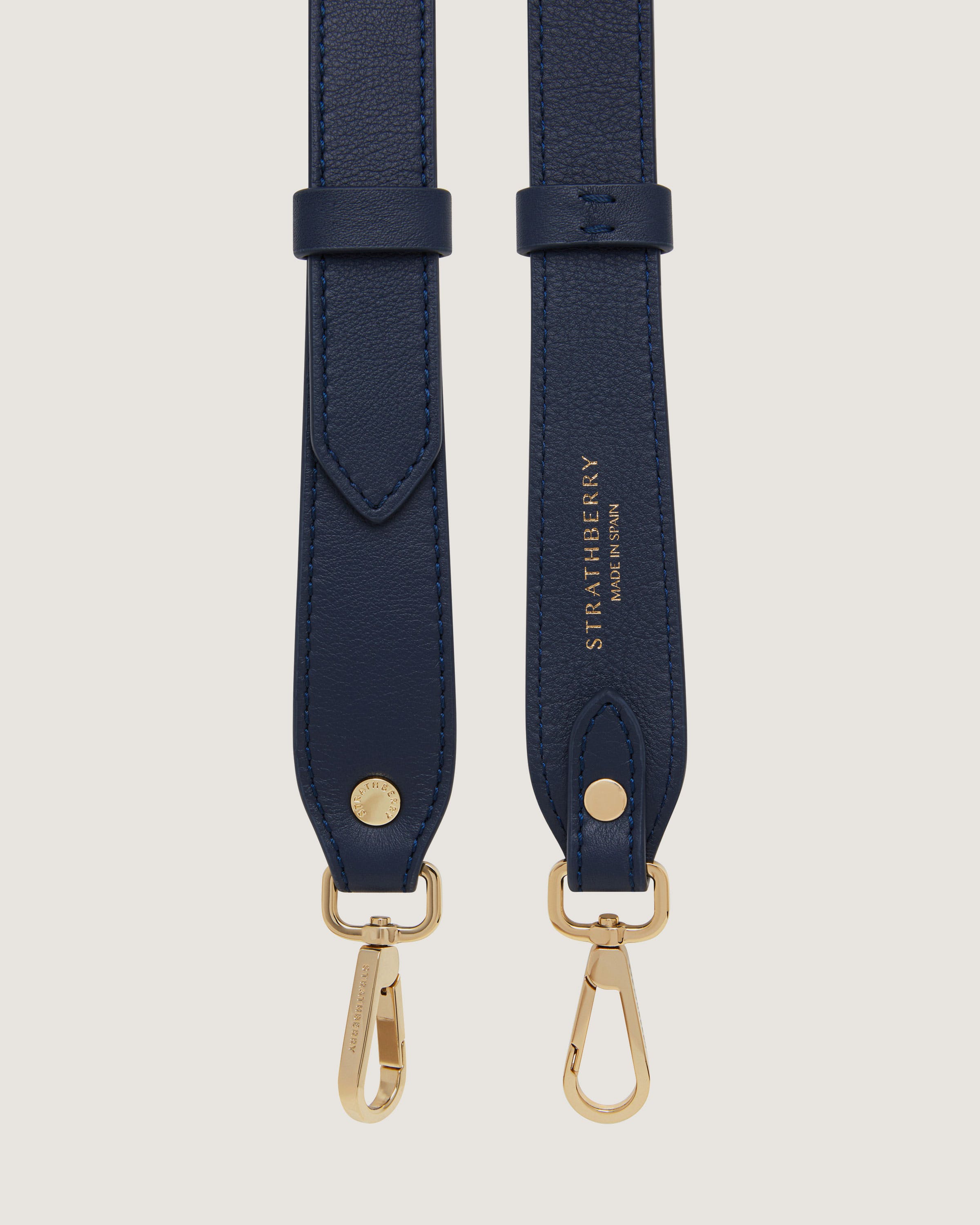 A pair of blue leather straps with gold hardware