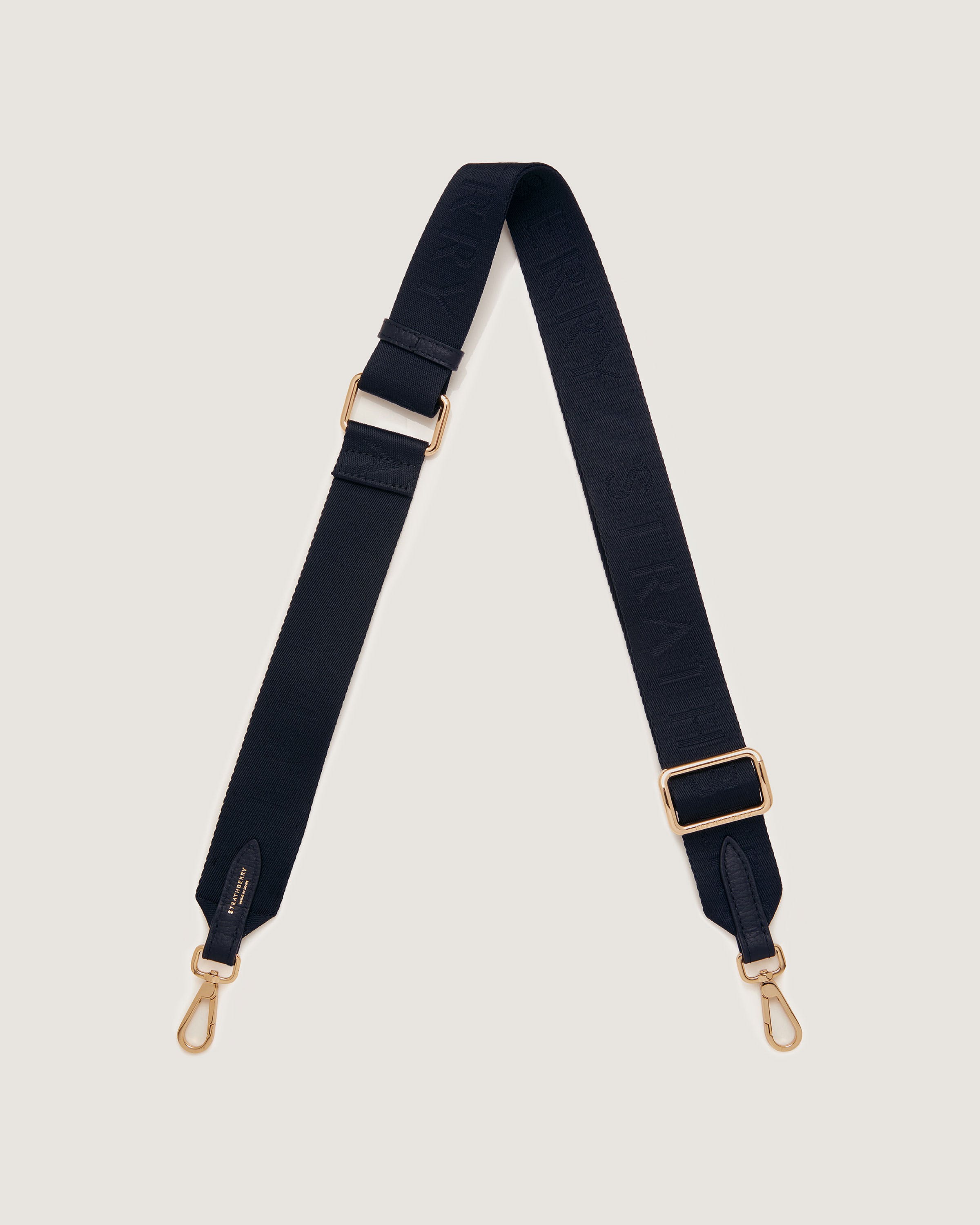 A black strap with a gold buckle on a white background