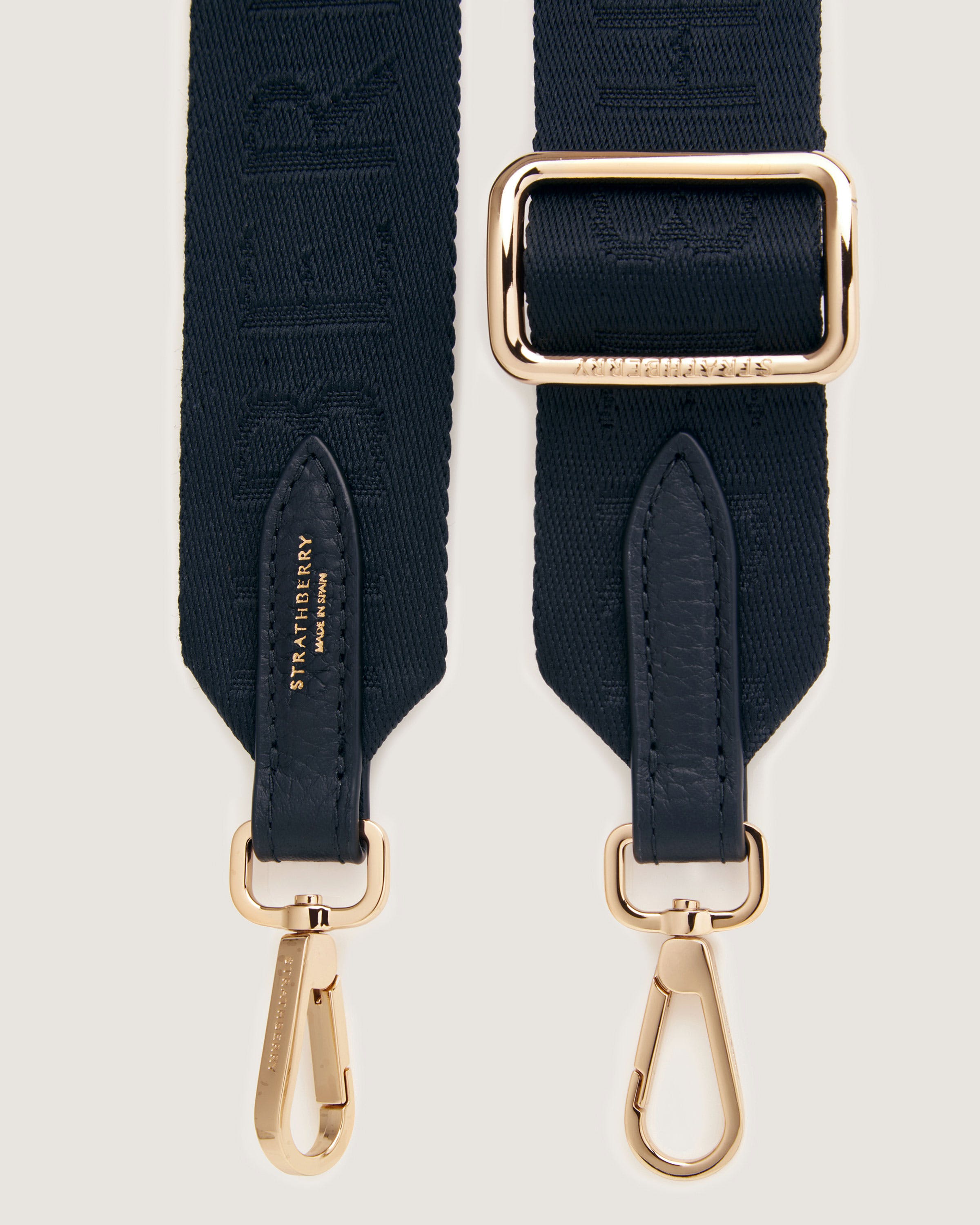 A pair of black straps with a gold buckle