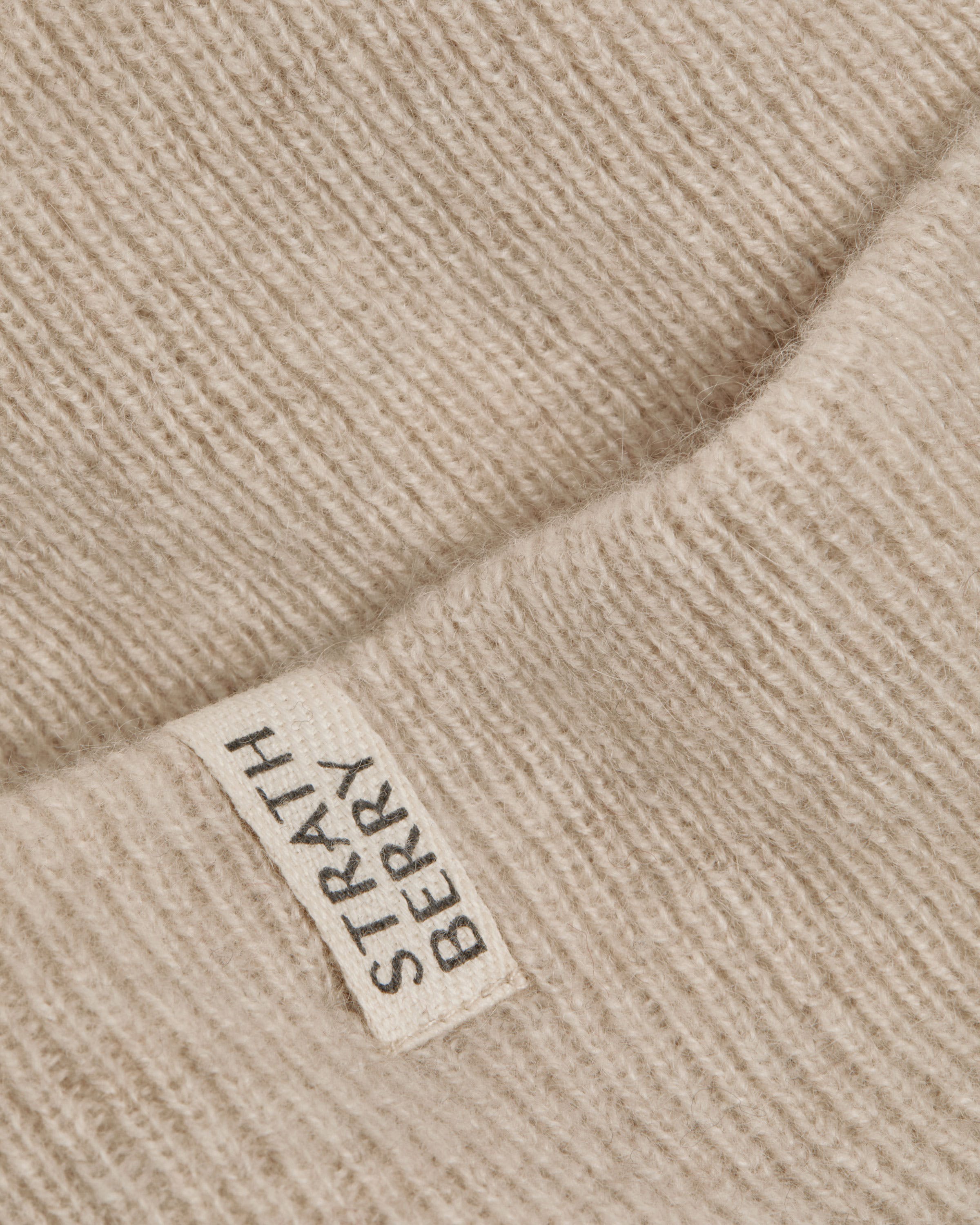 A label on a beige sweater that says, hi - seas