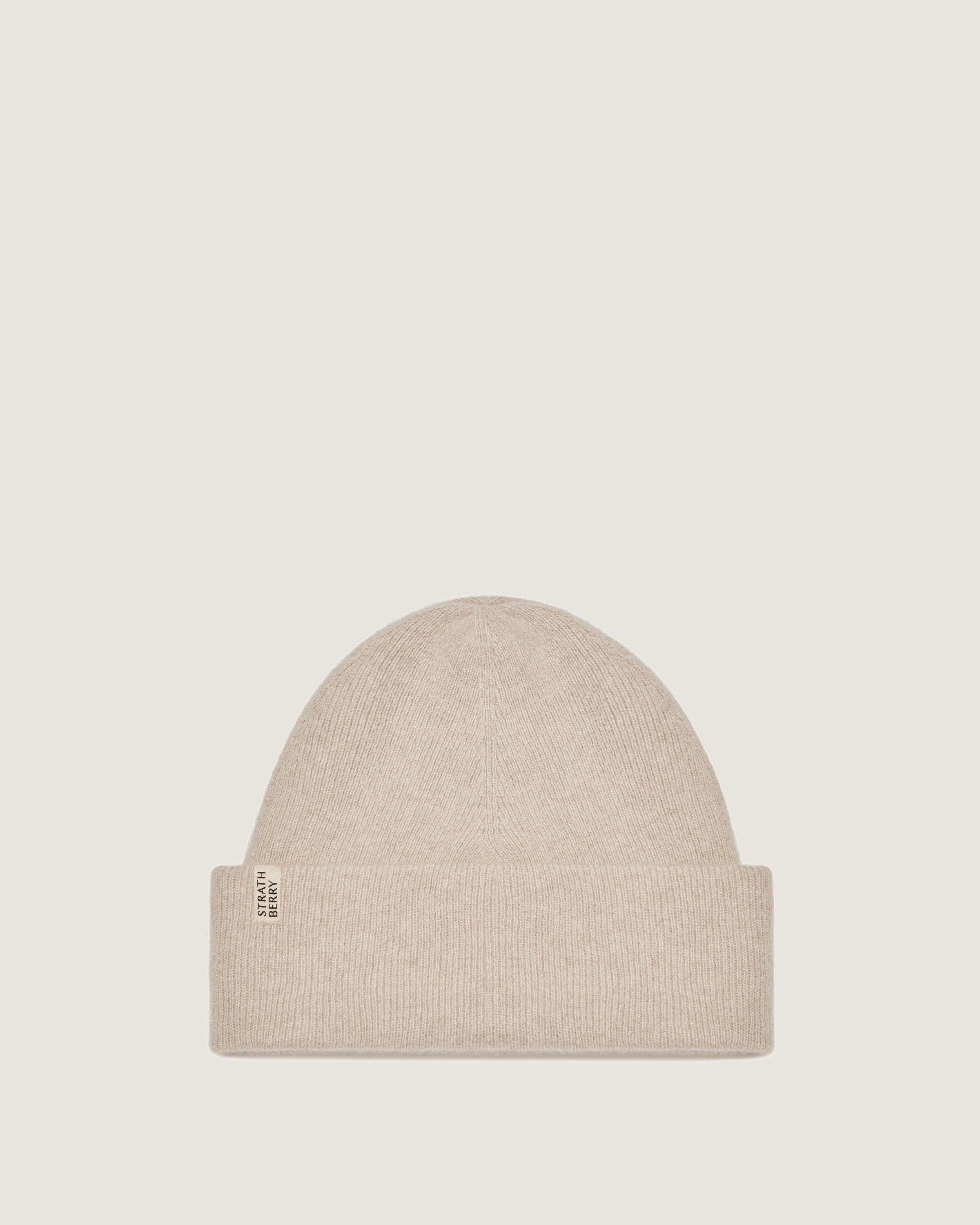 A beige beanie hat with a white label on the front