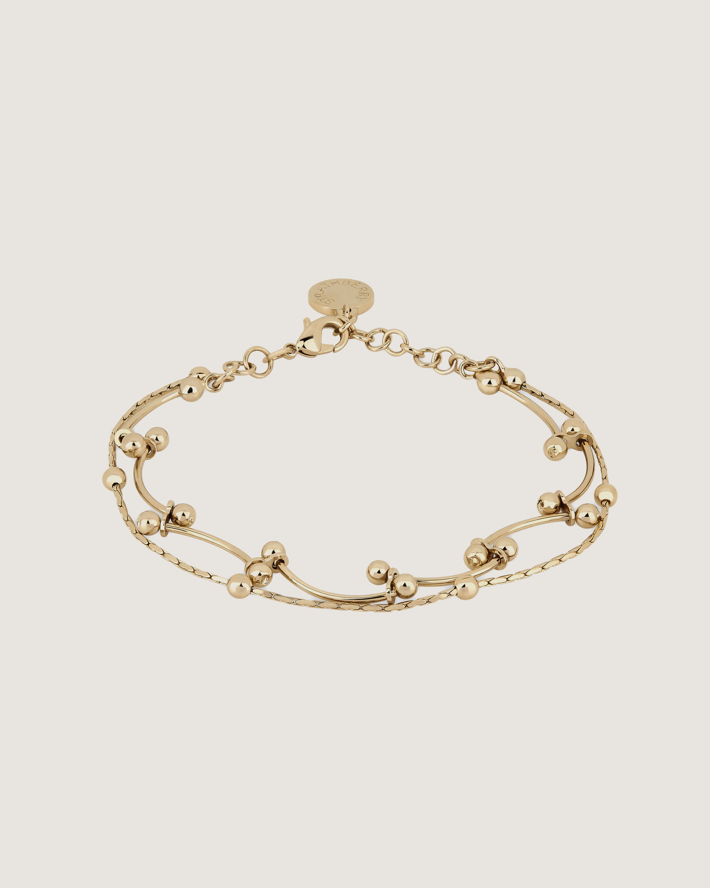 A gold bracelet with beads on a white background