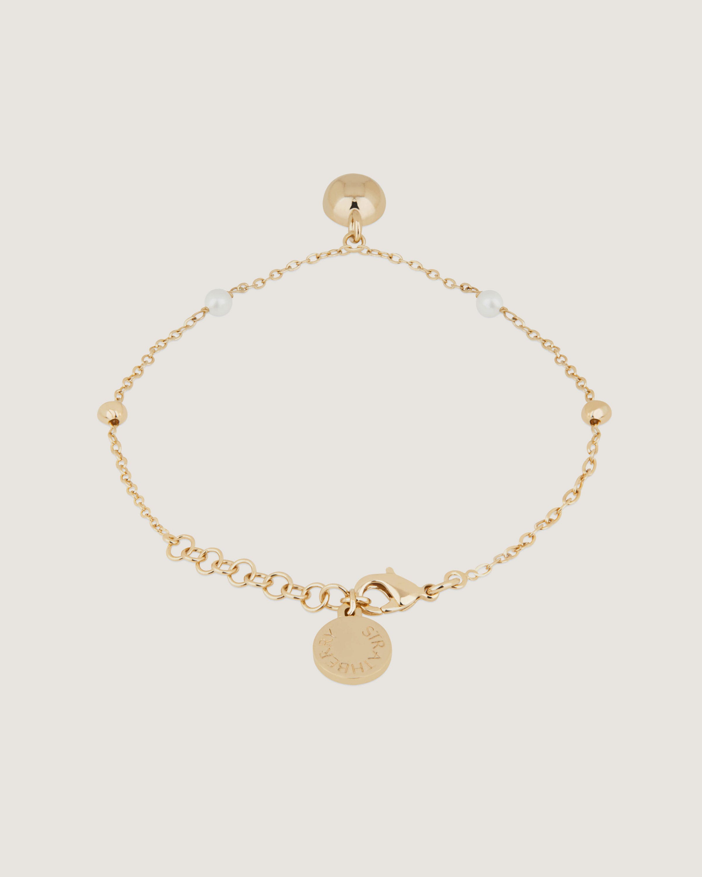 A gold bracelet with a small disc charm