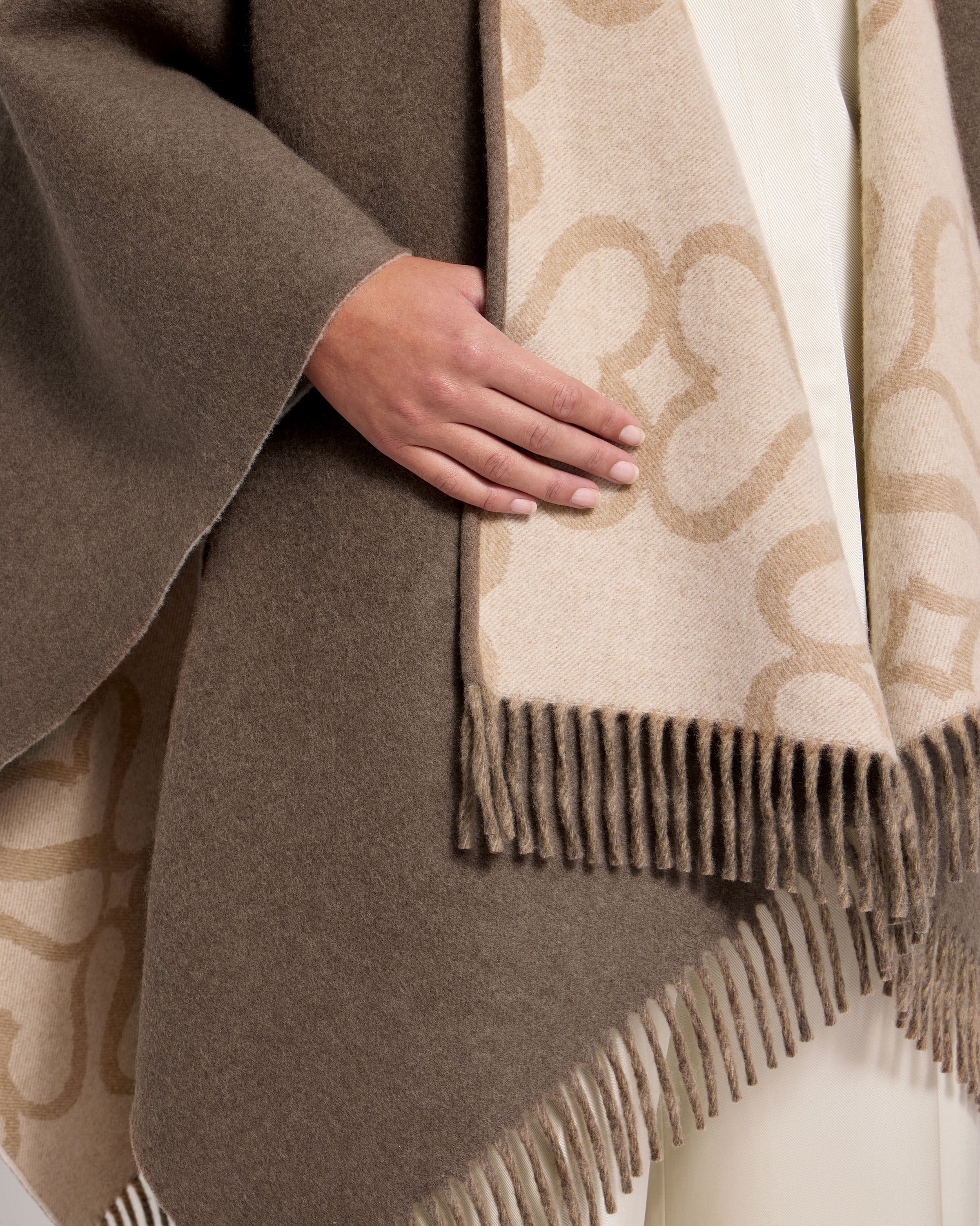 A close up of a person wearing a brown and white blanket