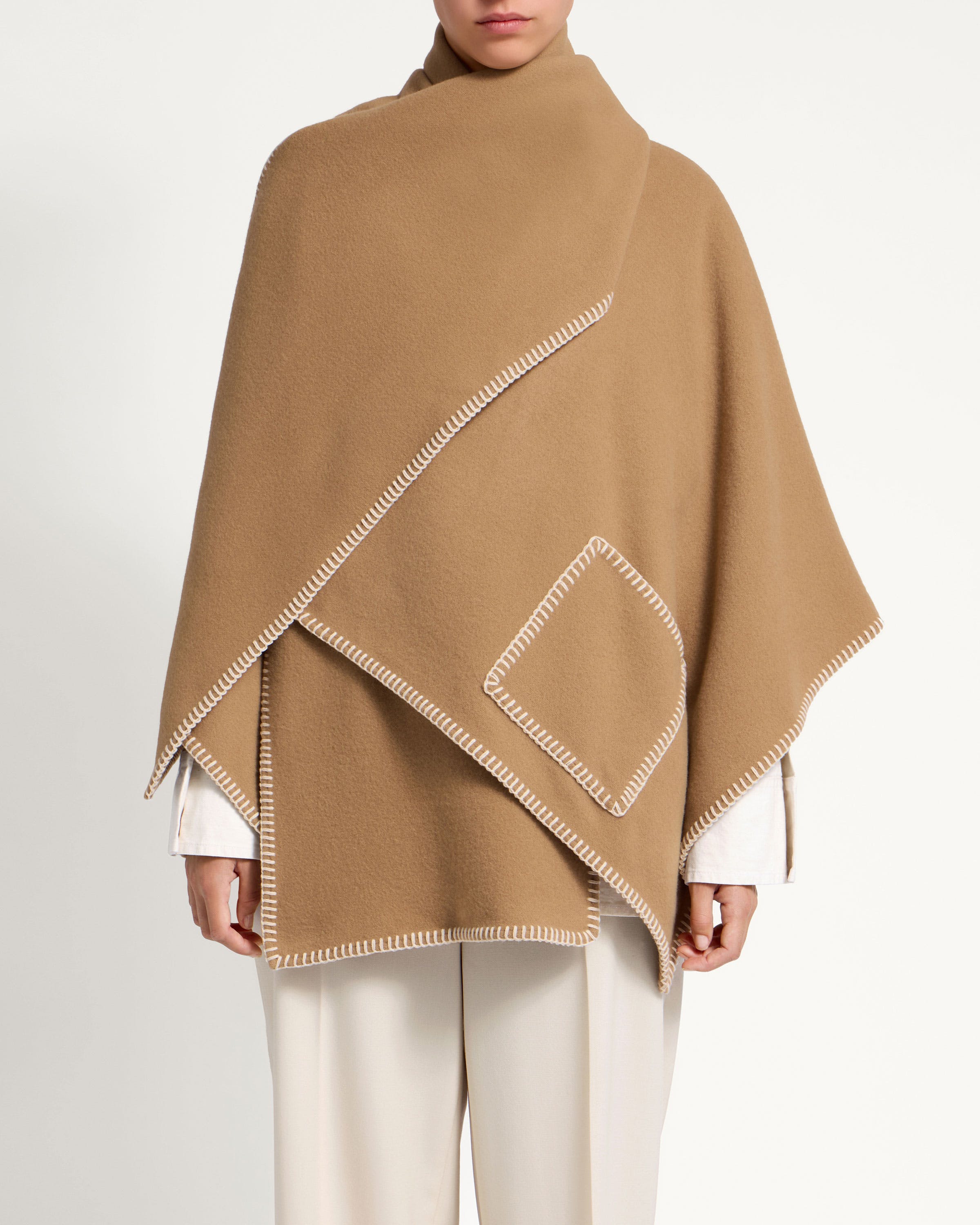 A woman is wearing a brown poncho