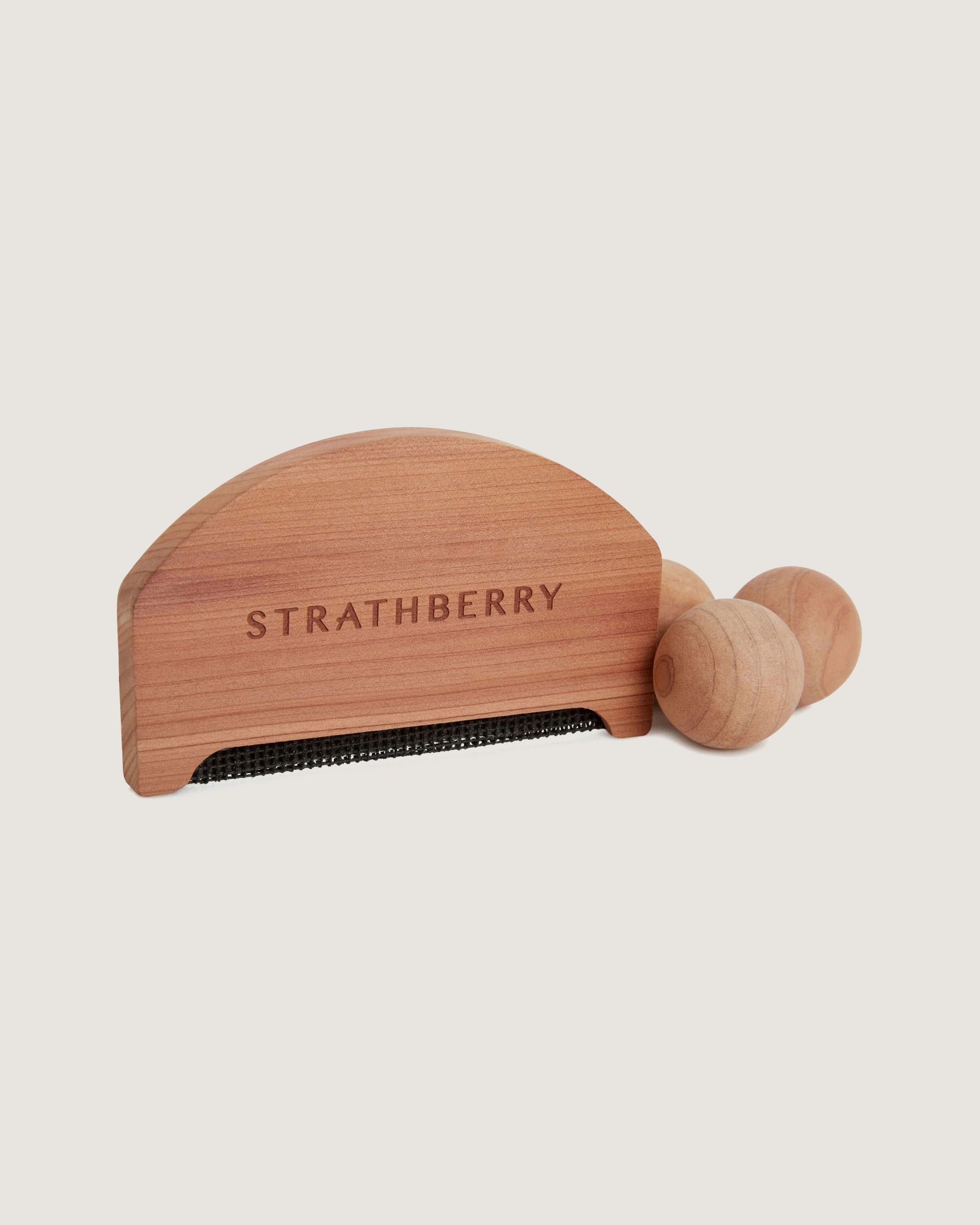 A wooden comb with the word, stratberry on it