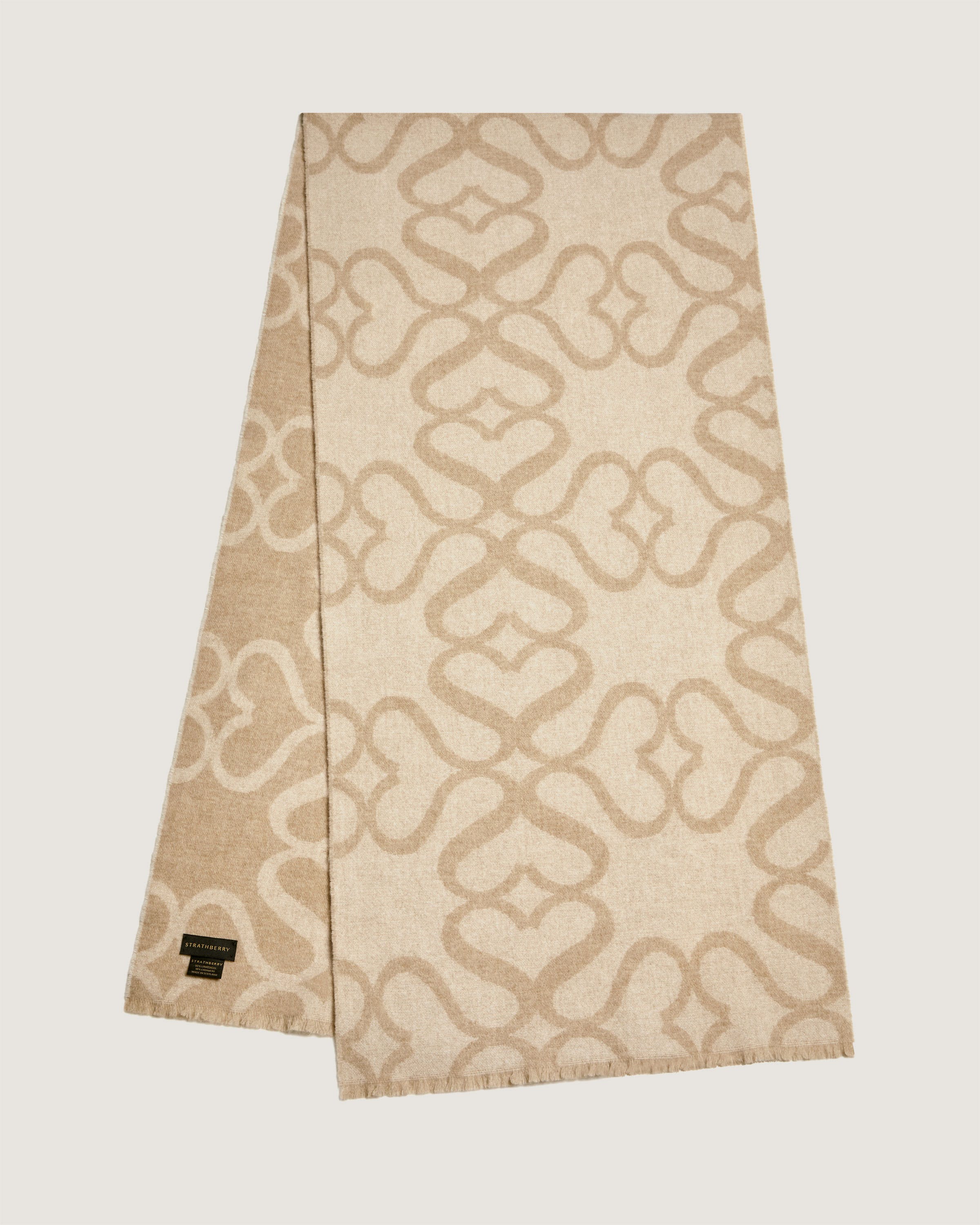 A tan and white scarf with a design on it