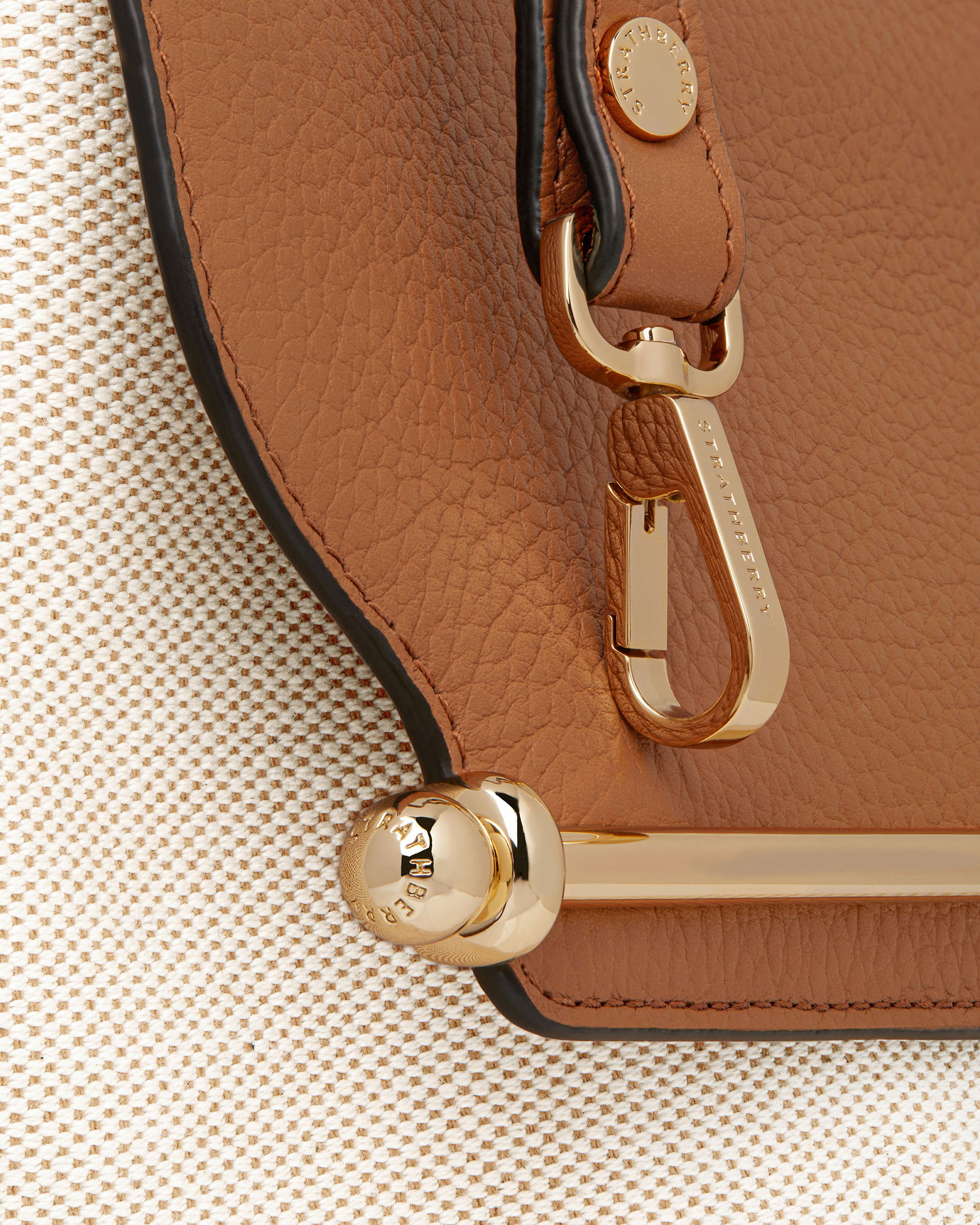 A close up of a brown purse with a gold handle