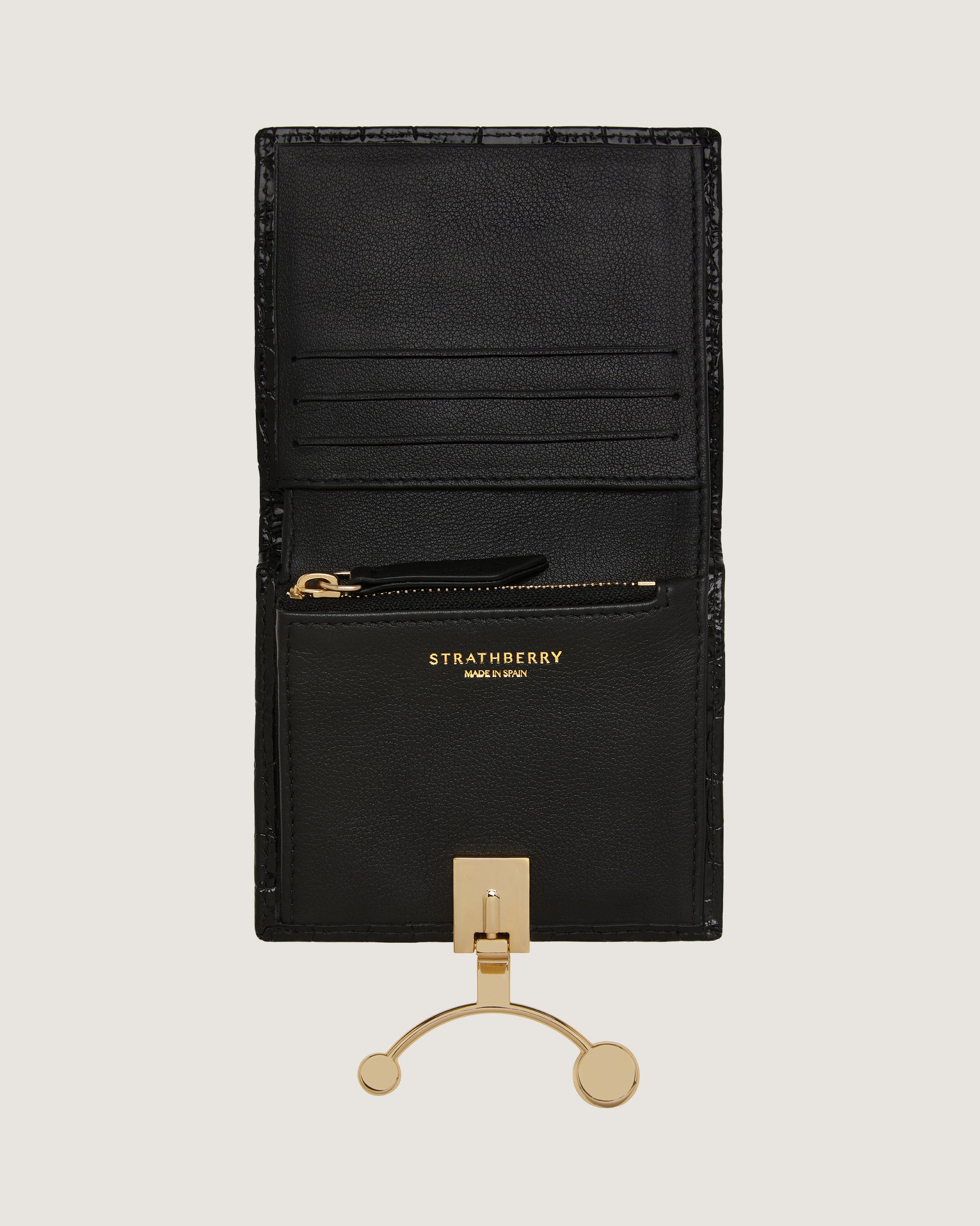 A black leather wallet with a gold metal hook