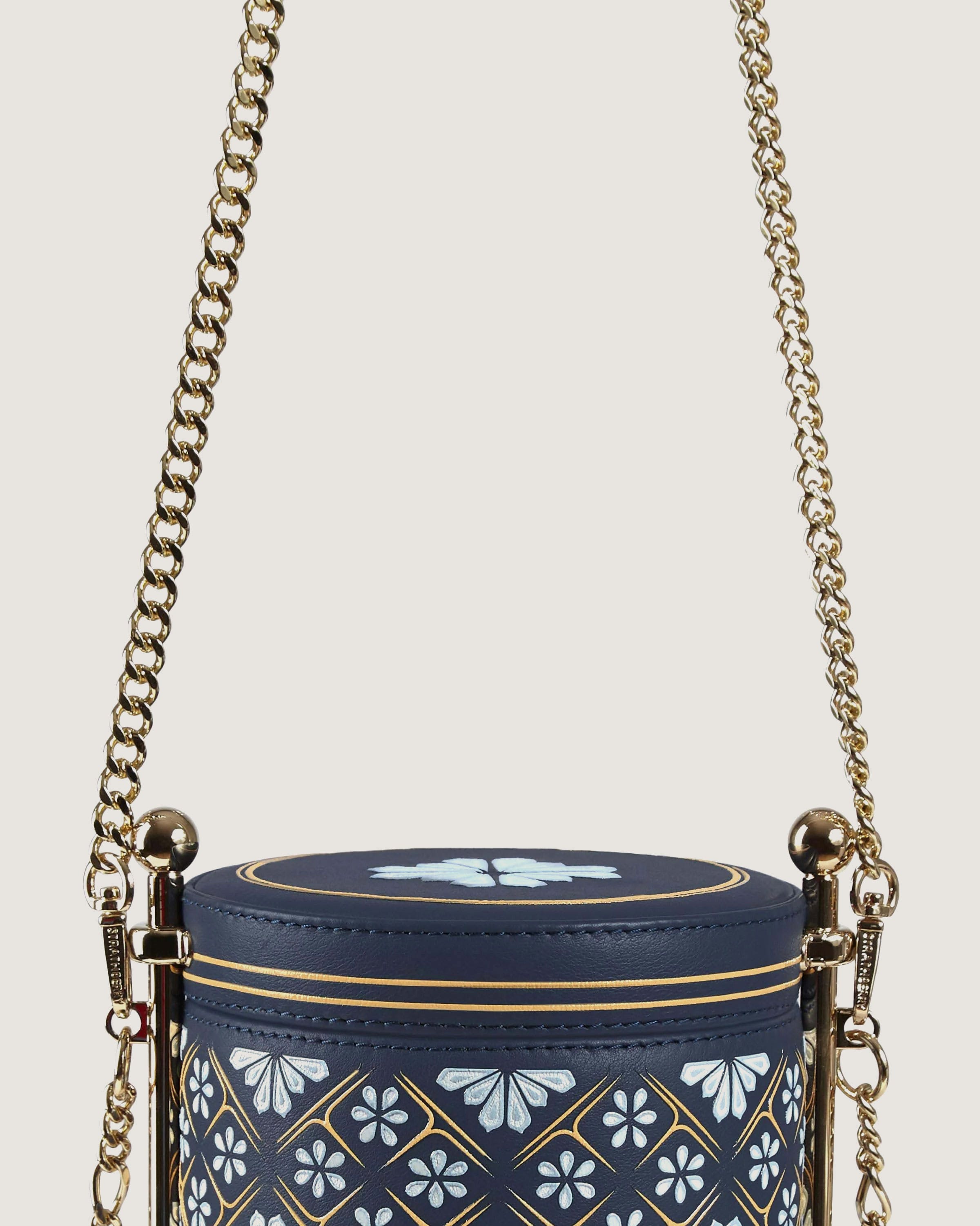 A blue and gold purse with a chain hanging from it