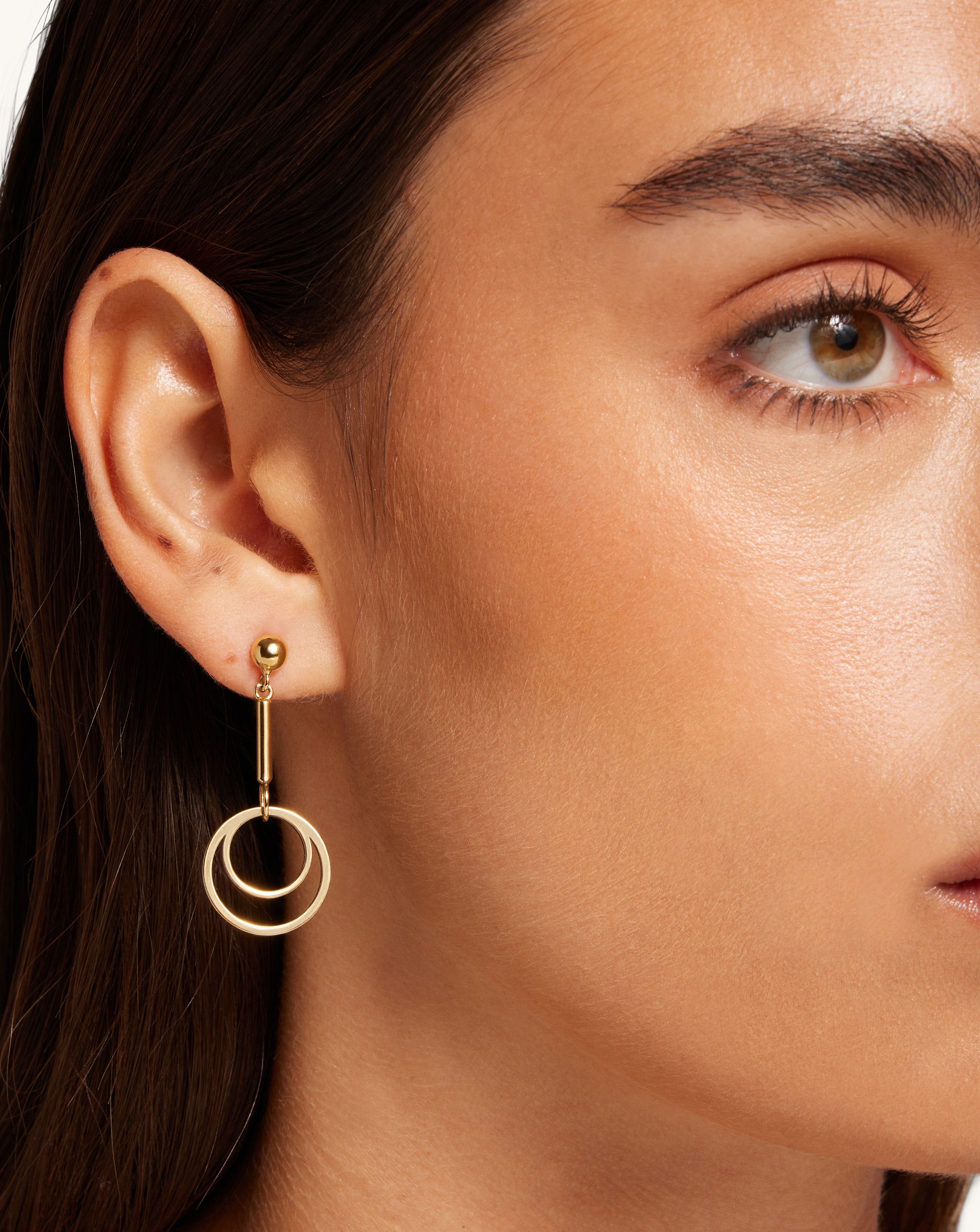 A close up of a person wearing a pair of earrings