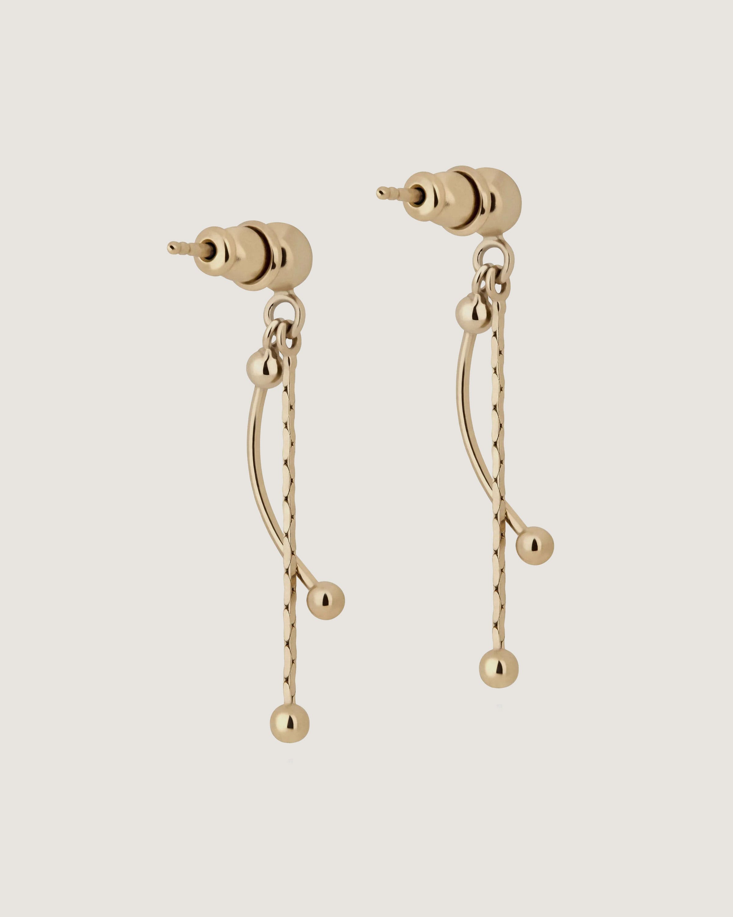 A pair of gold earrings with a chain hanging from it