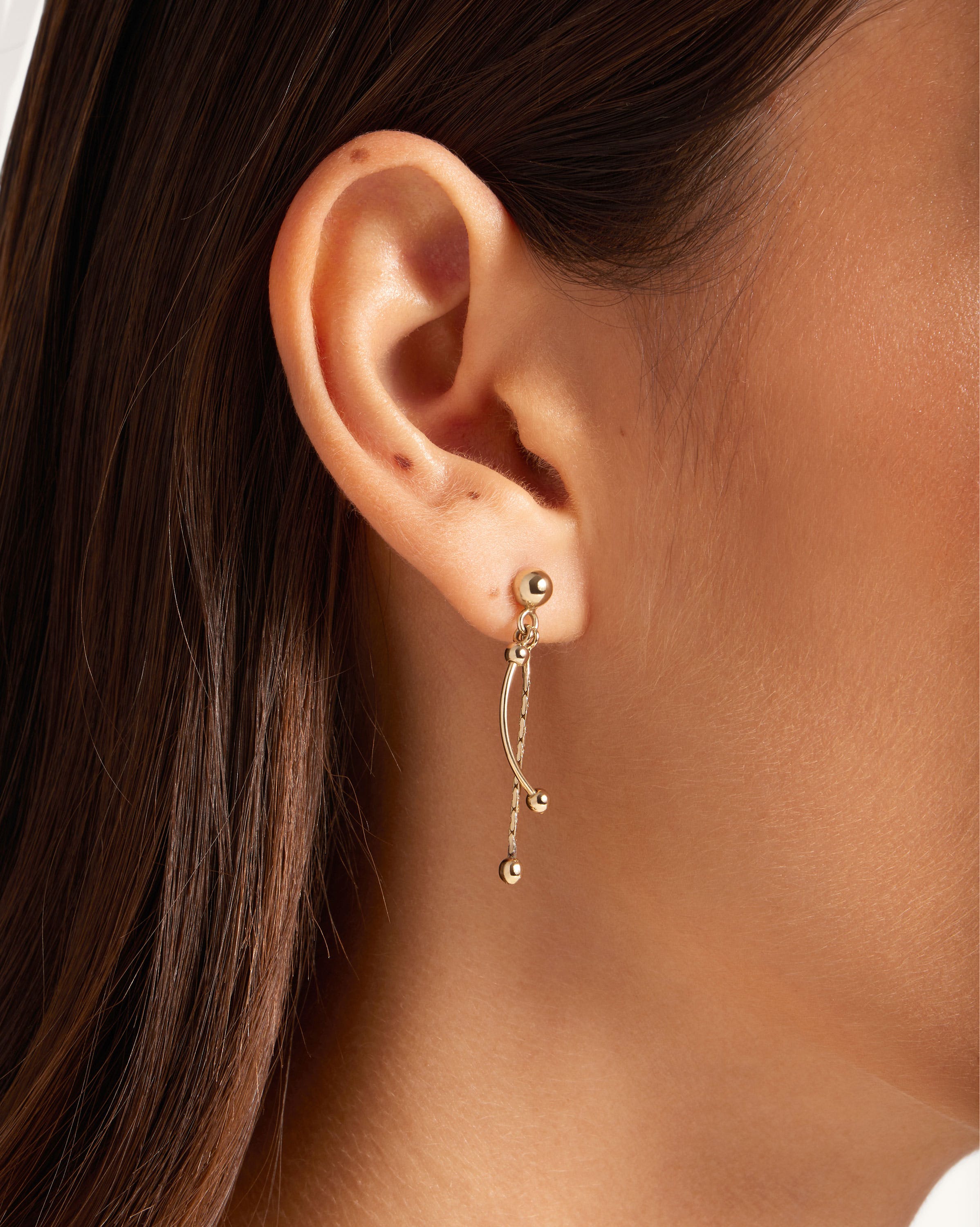 A close up of a person wearing a pair of earrings