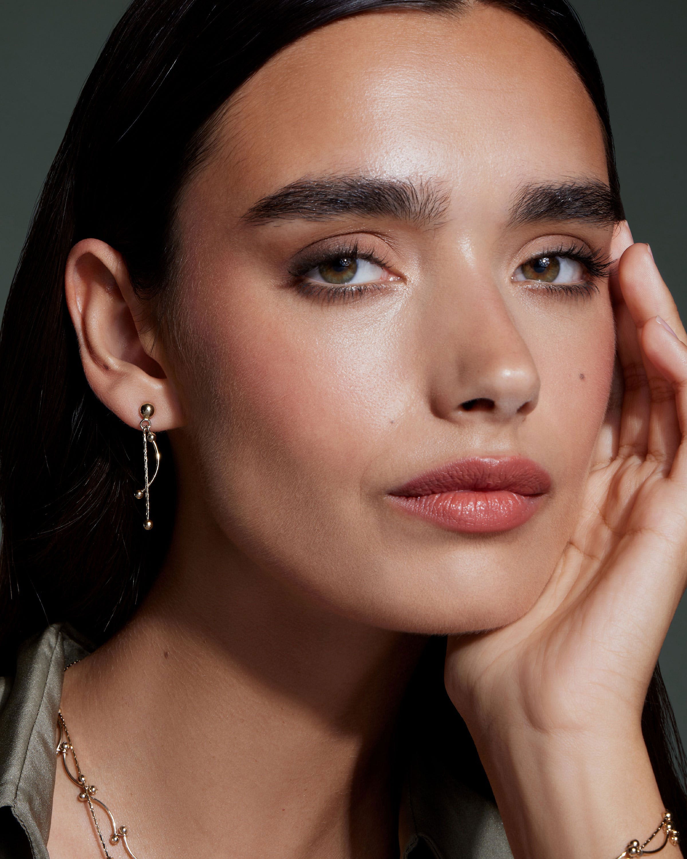 A woman wearing a necklace and earrings