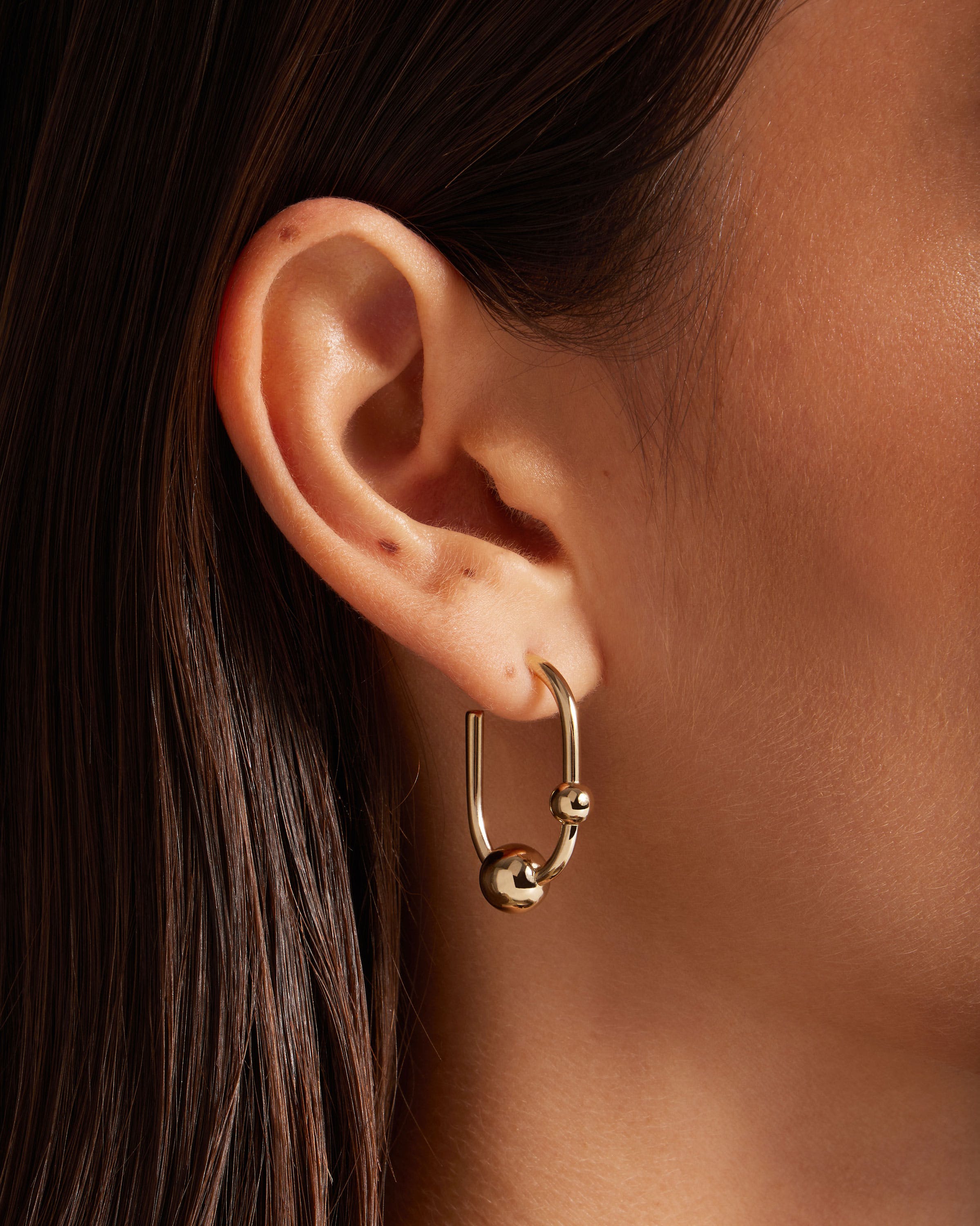 A close up of a person wearing a pair of earrings