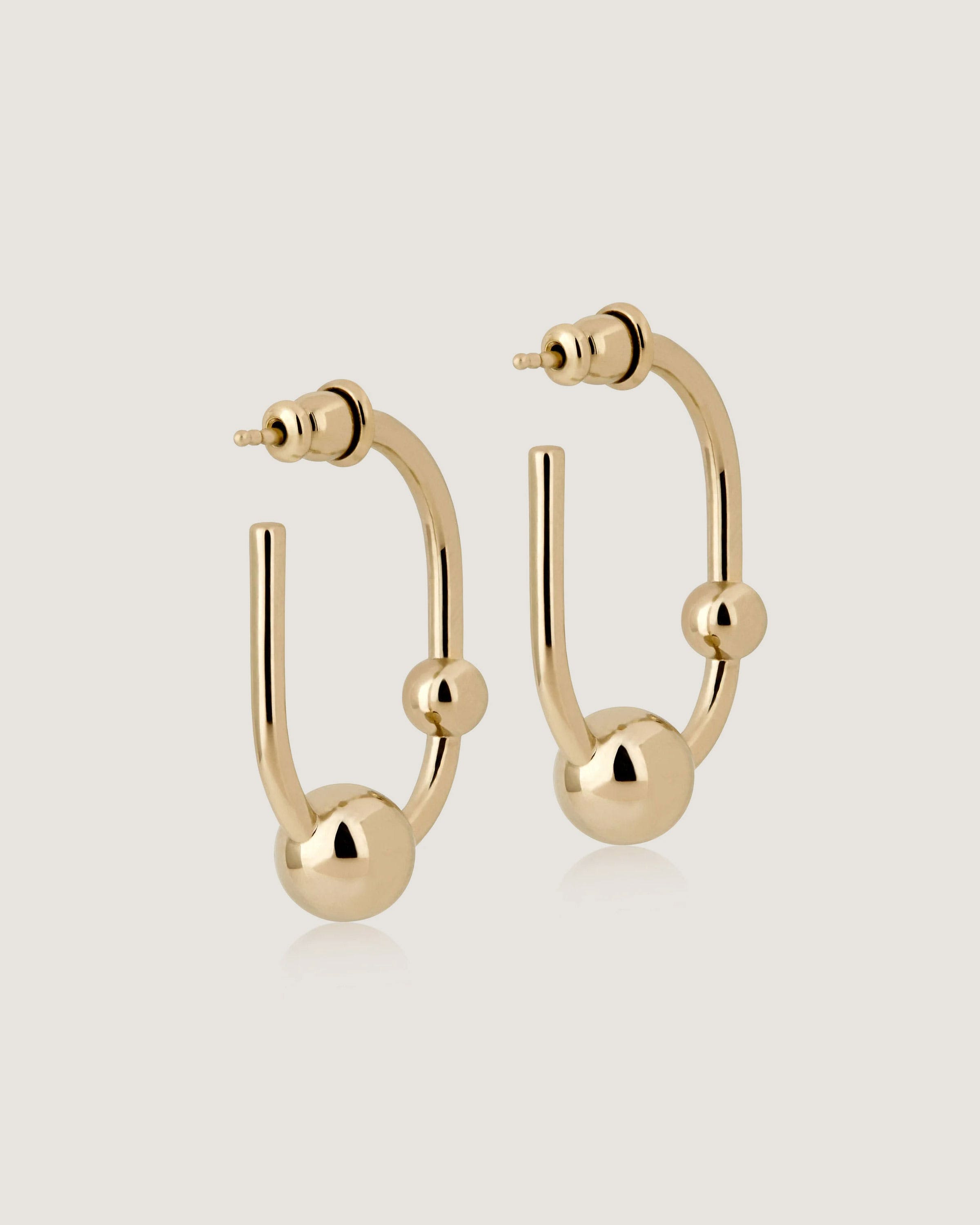 A pair of gold hoop earrings on a white background