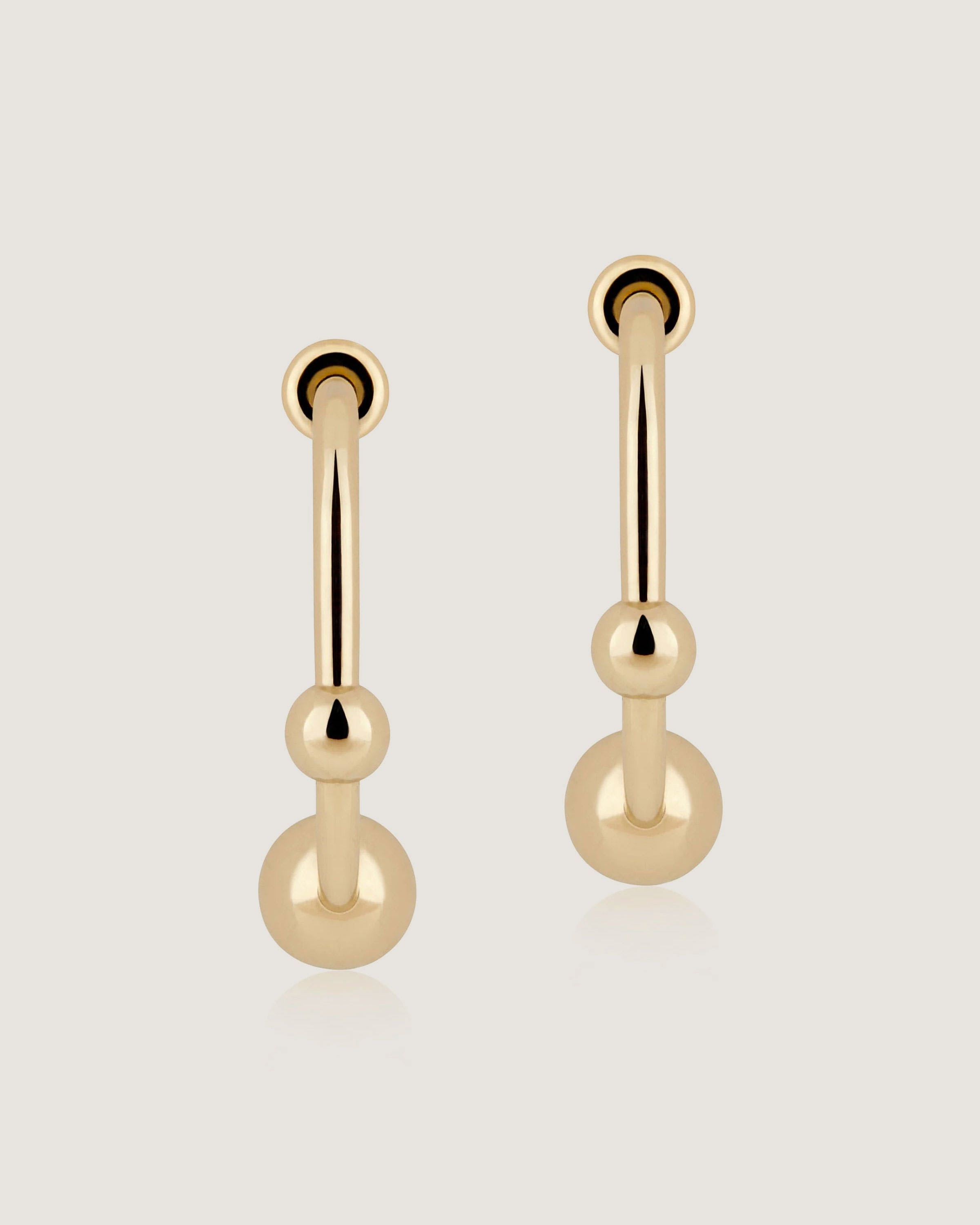 A pair of gold earrings on a white background