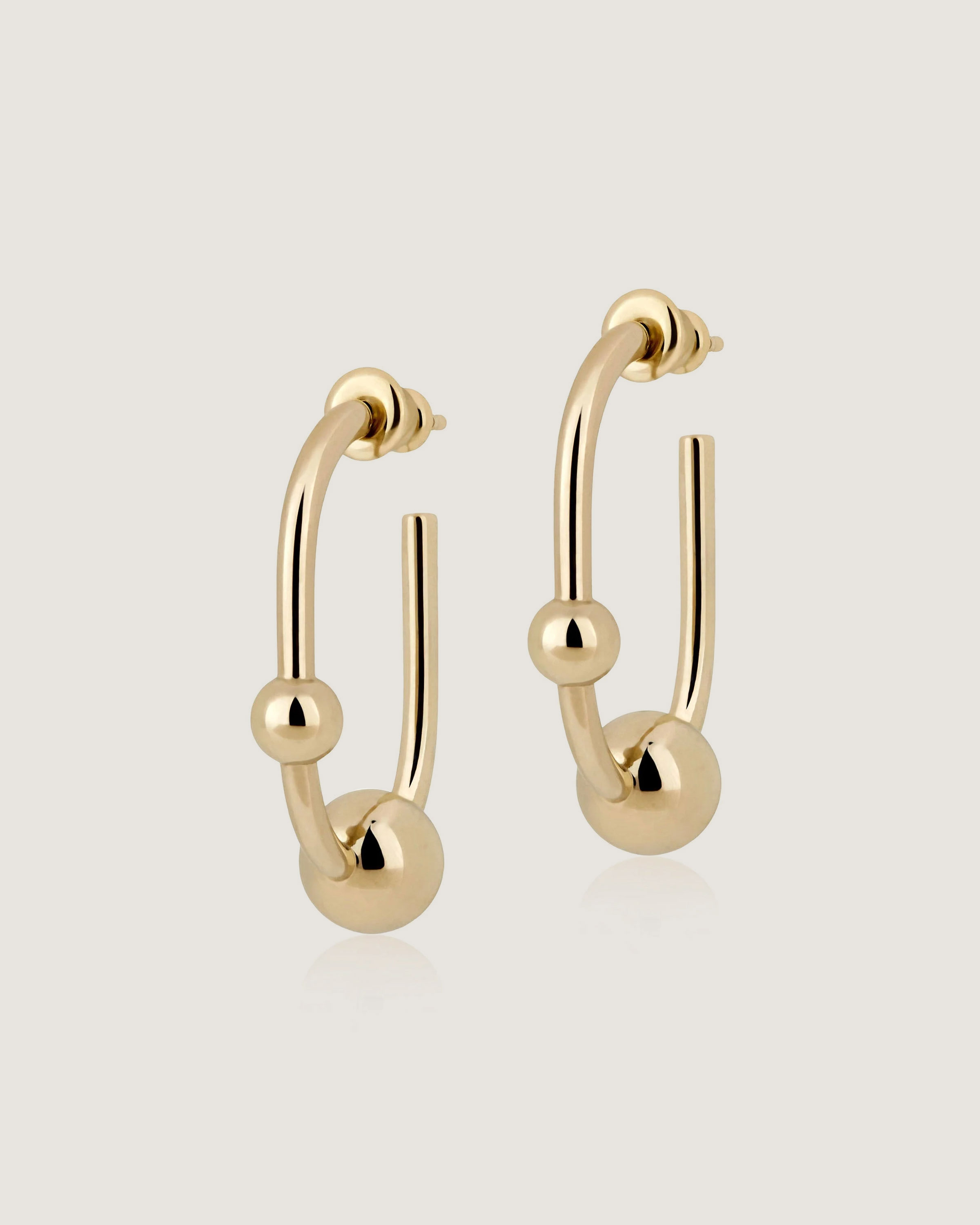 A pair of gold hoop earrings on a white background